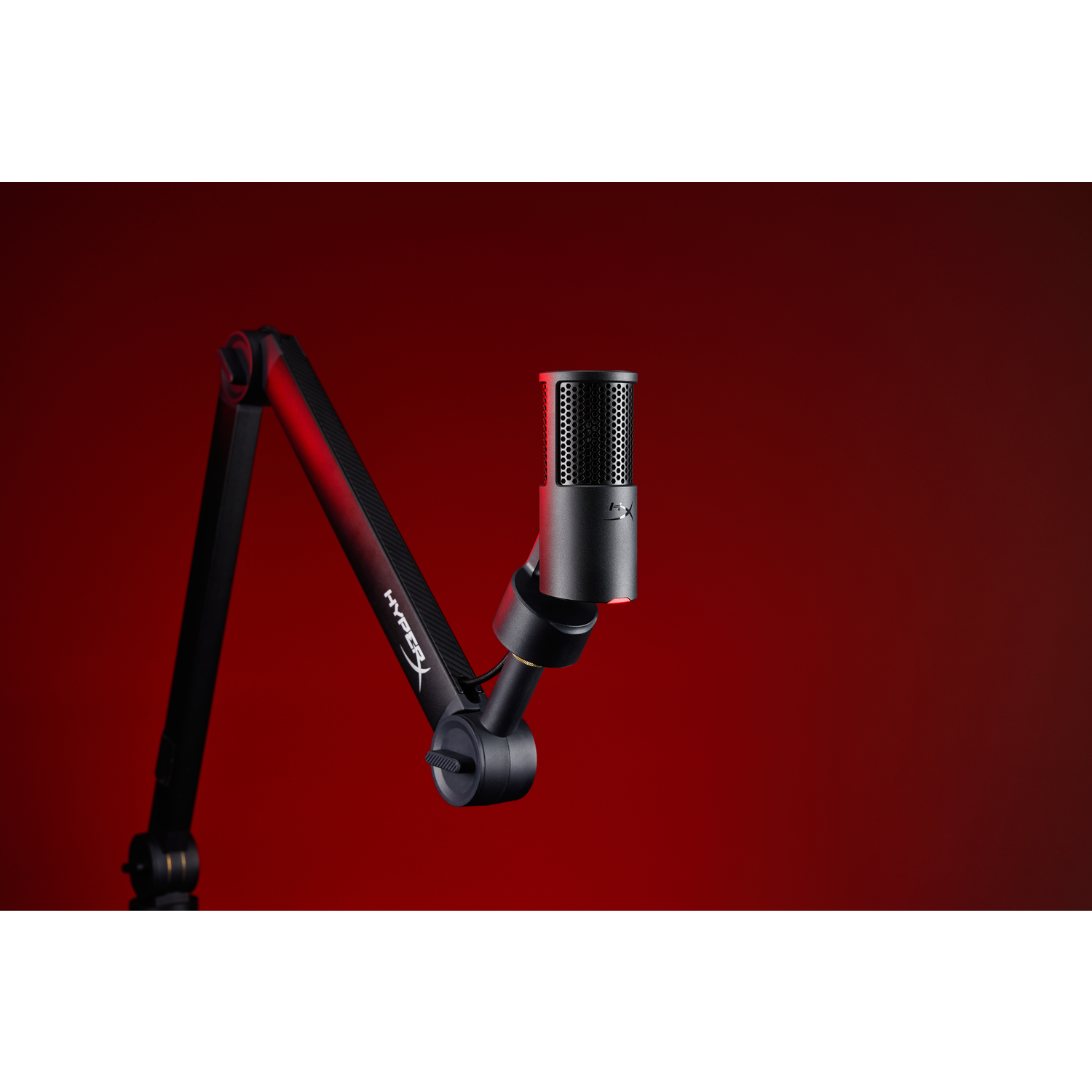 A black microphone with a mesh head is mounted on a black articulated arm against a red background.