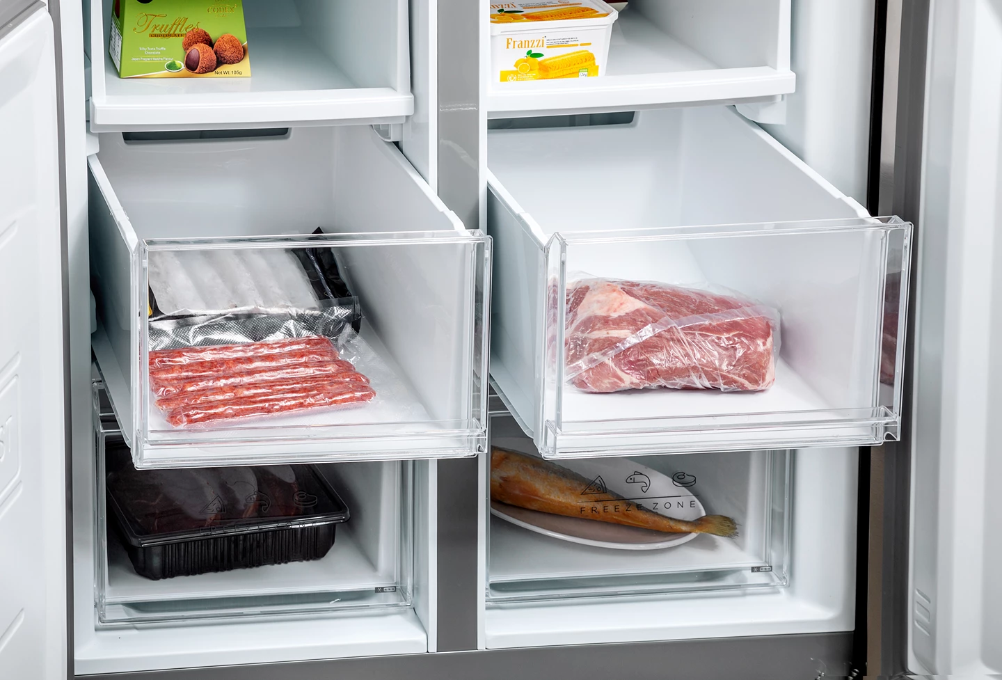Kühlschrankinnenraum mit verpacktem Fleisch, Fisch und Tiefkühlkost. Schubladen sind geöffnet und zeigen den Inhalt. Tabletts mit Essen sind sichtbar.