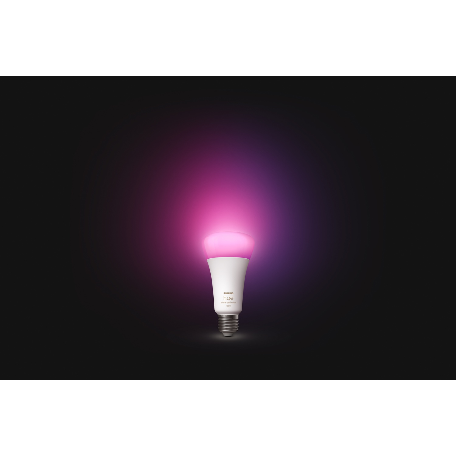 Una lampadina intelligente Philips Hue si illumina di rosa su sfondo nero. La lampadina è bianca, con base argentata, e la parte superiore brilla di rosa.