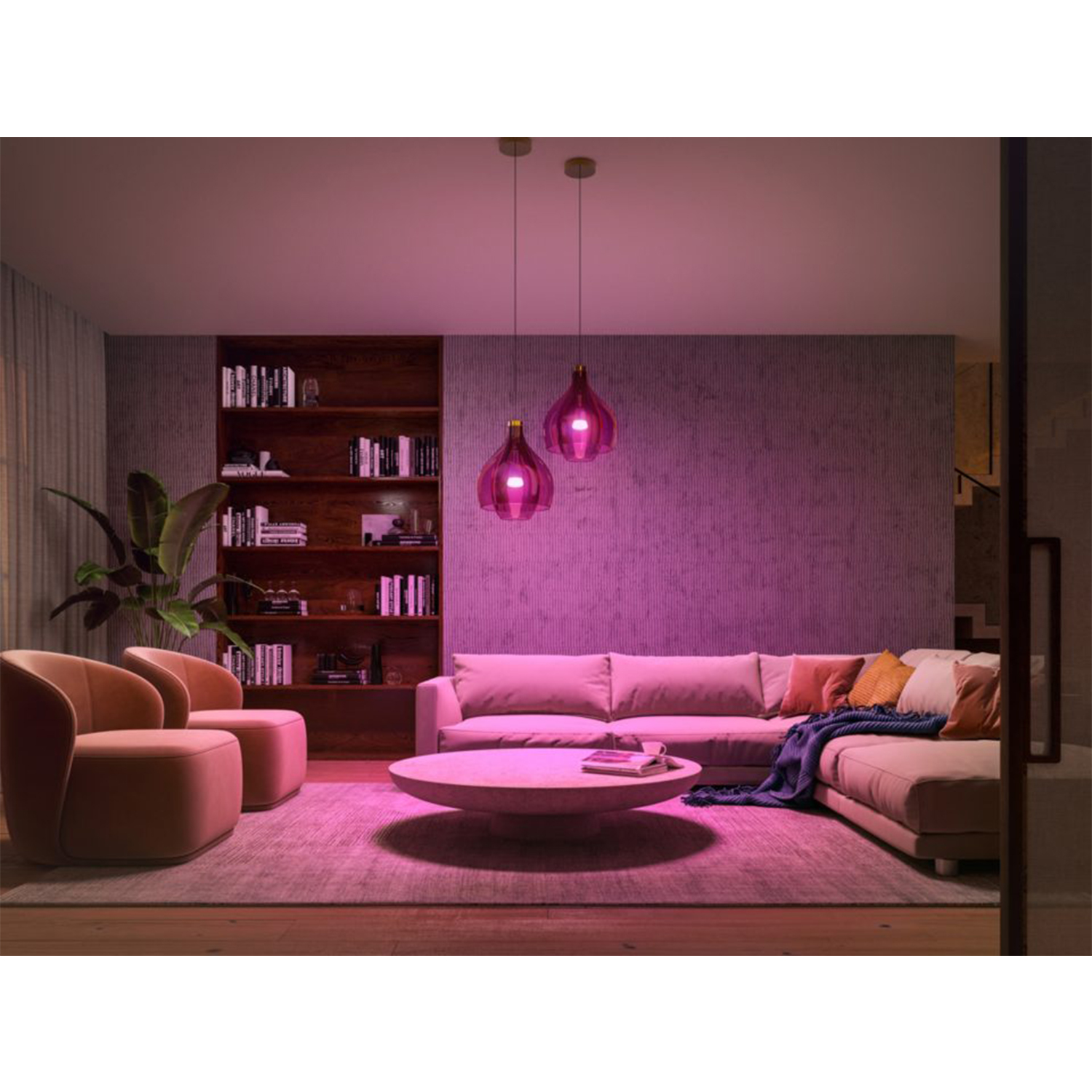 Soggiorno illuminato con luce rosa. Include un divano, due sedie, un tavolino, una libreria e due lampade a sospensione.