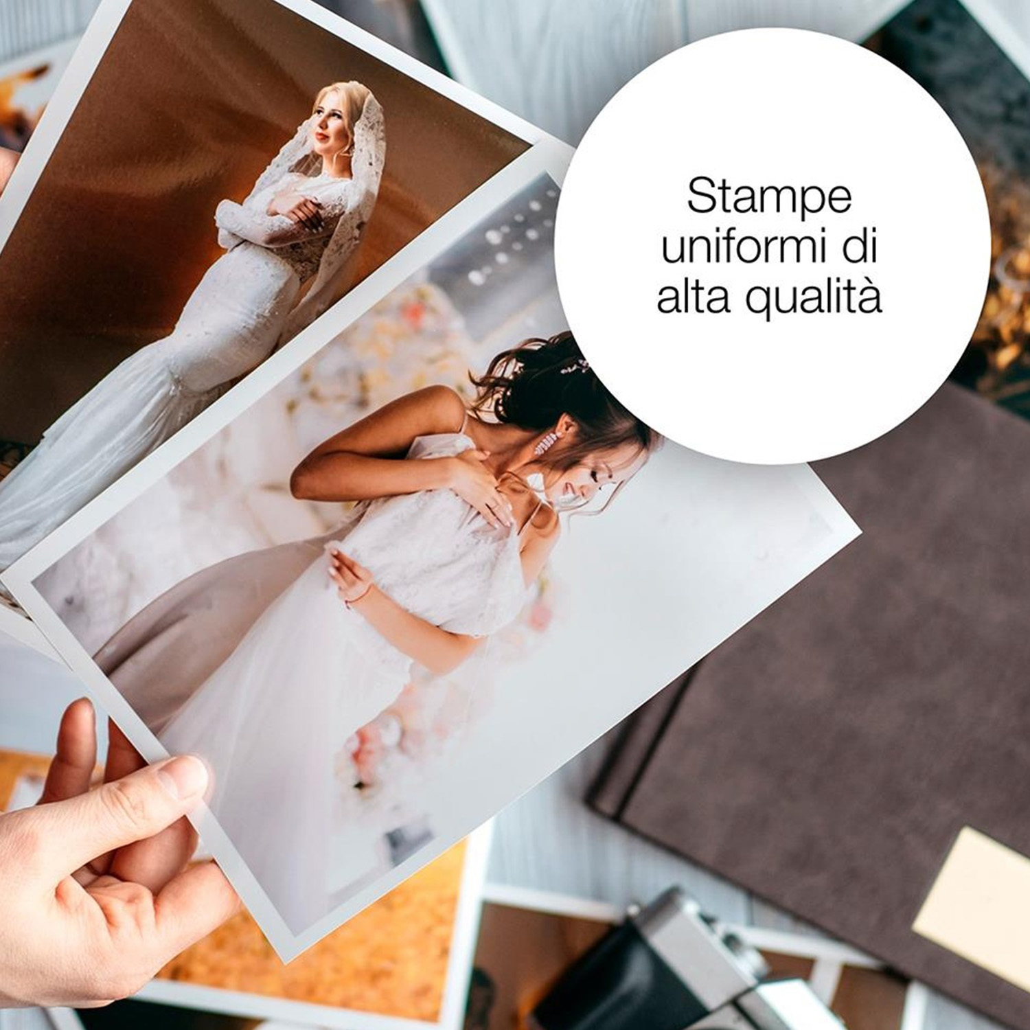 Una mano che tiene foto di matrimonio, con spose in abiti bianchi. Sono visibili anche un album fotografico e una fotocamera.