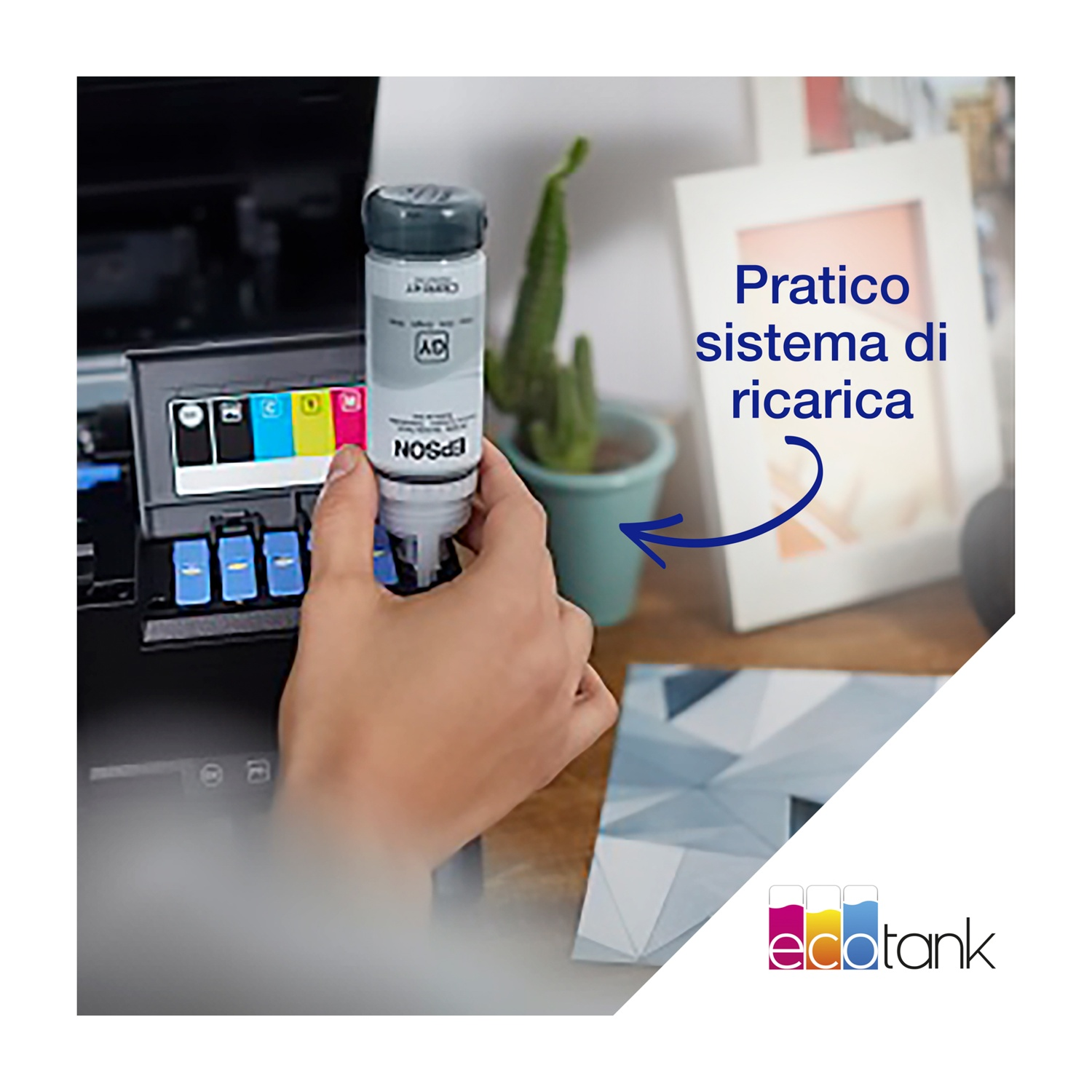 Una mano tiene una bottiglia di inchiostro Epson vicino a una stampante. Un cactus e una cornice sono sullo sfondo.