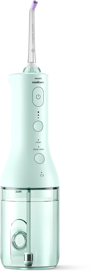 Egy Philips Sonicare szájzuhany, világoszöld, lila heggyel. Van rajta bekapcsoló, tisztító és mélytisztító gomb.