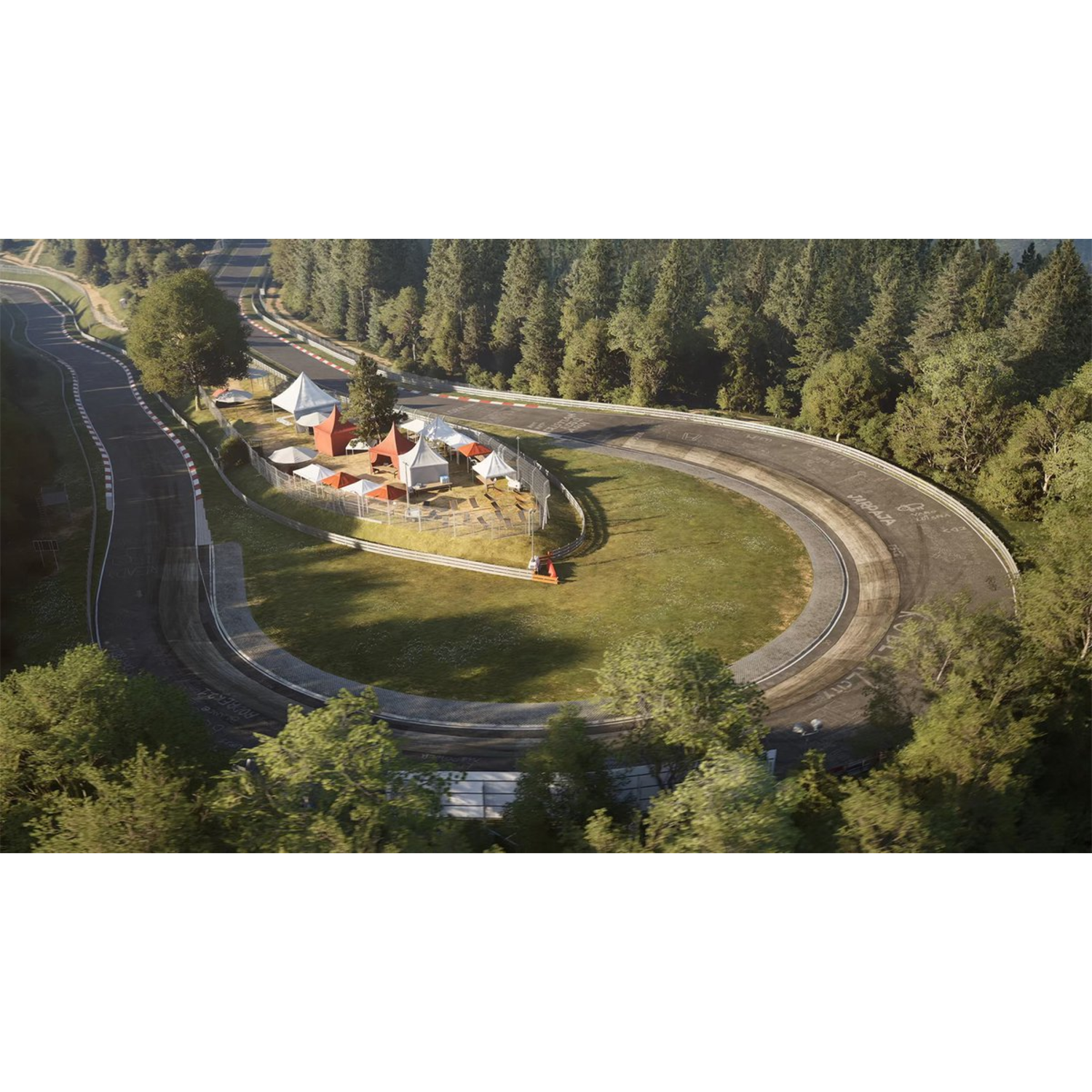Aerial view of a race track winding through a forest. Tents and structures are in the infield.