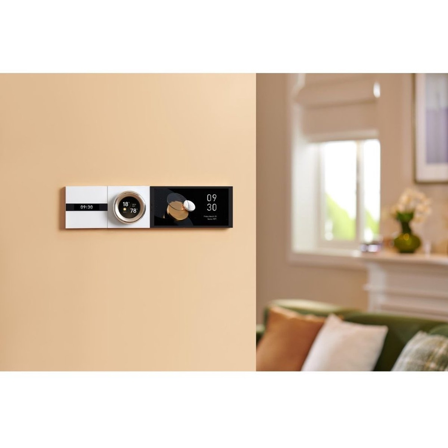 A wall-mounted smart home control panel displaying time, temperature, and other information. A green sofa with pillows is in the background.
