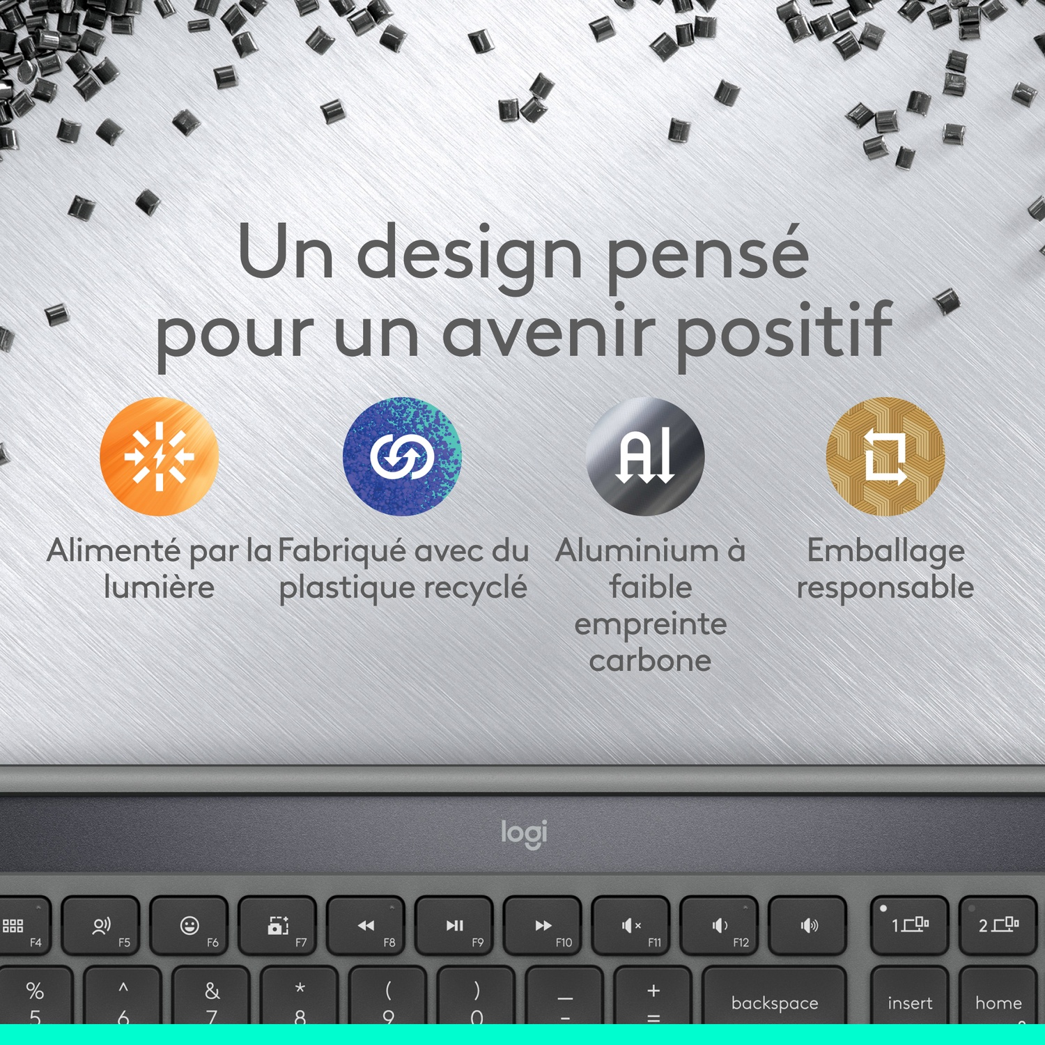 Un clavier avec du texte en français, y compris des icônes et du texte sur la conception durable, avec des touches gris foncé et un fond métallique.