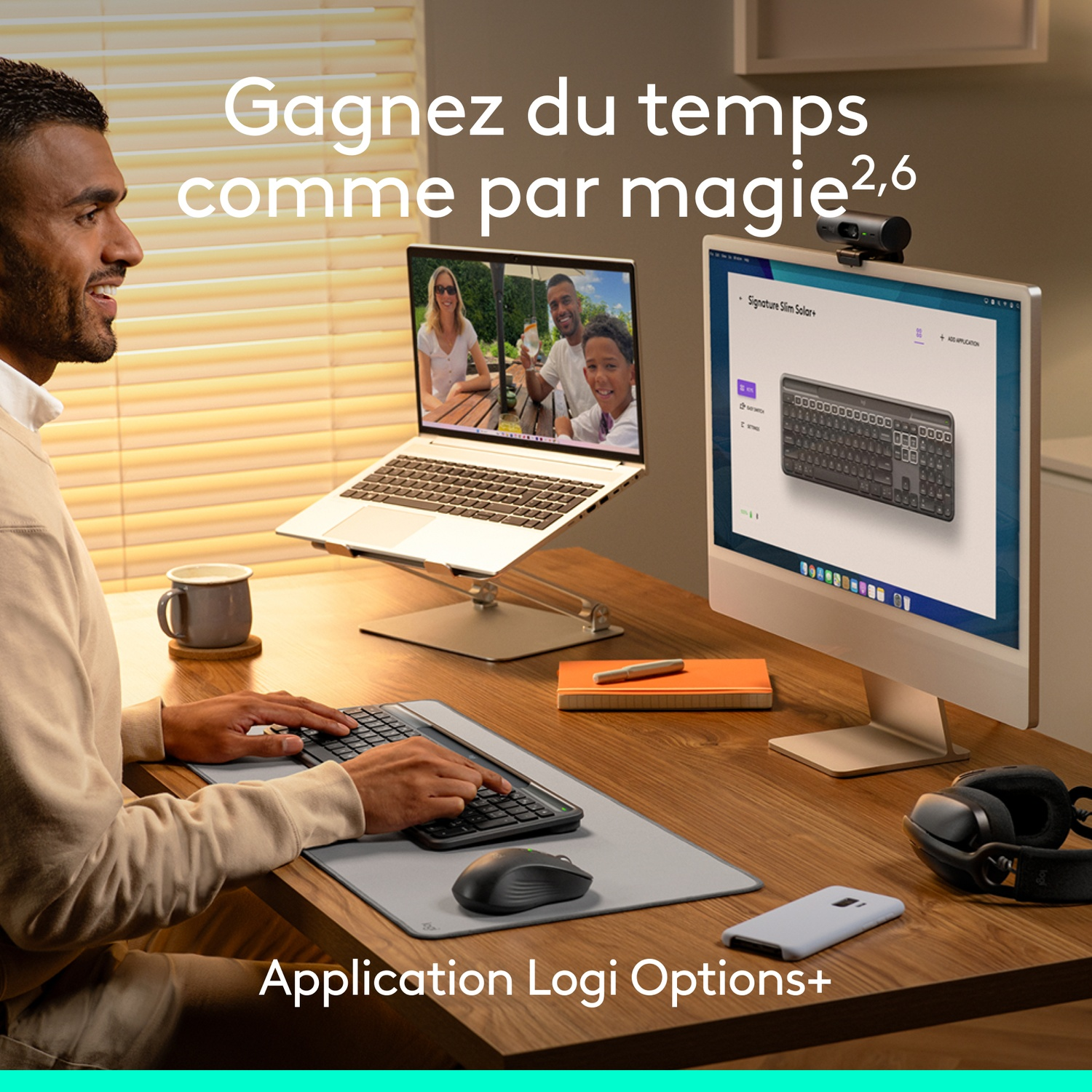 Un homme travaille sur un ordinateur avec un clavier et une souris. Un ordinateur portable affiche un appel vidéo. Une tasse et un casque sont sur le bureau.