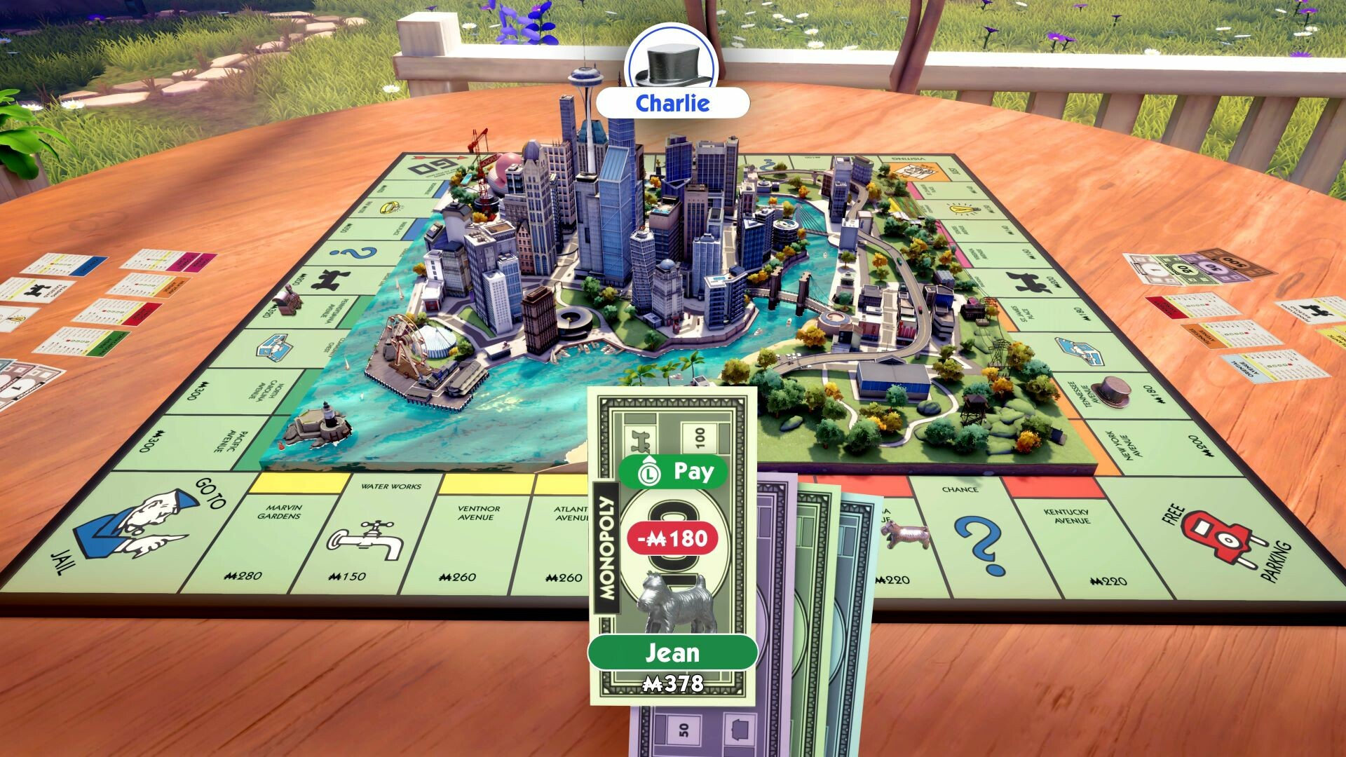 Monopoly-Brettspiel mit einer Stadt in der Mitte. Banknoten und Karten sind sichtbar. Zwei Spieler heißen Charlie und Jean.