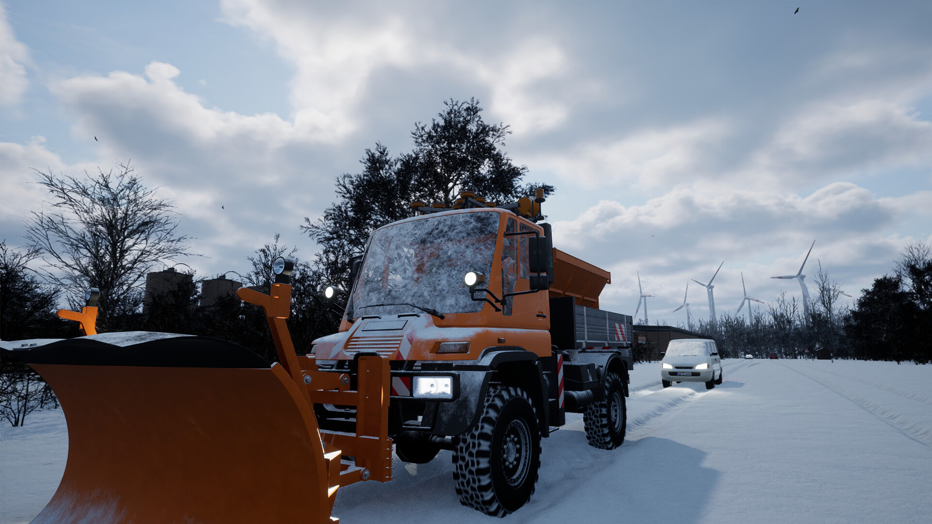 Ein orangefarbener Schneepflug räumt eine verschneite Straße frei. Ein weißer Transporter folgt. Windräder und kahle Bäume sind im Hintergrund.