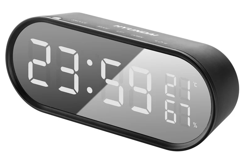 Czarny cyfrowy budzik Hyundai wyświetla czas, temperaturę i wilgotność. Godzina to 23:59. Temperatura wynosi 21°C, a wilgotność 67%.
