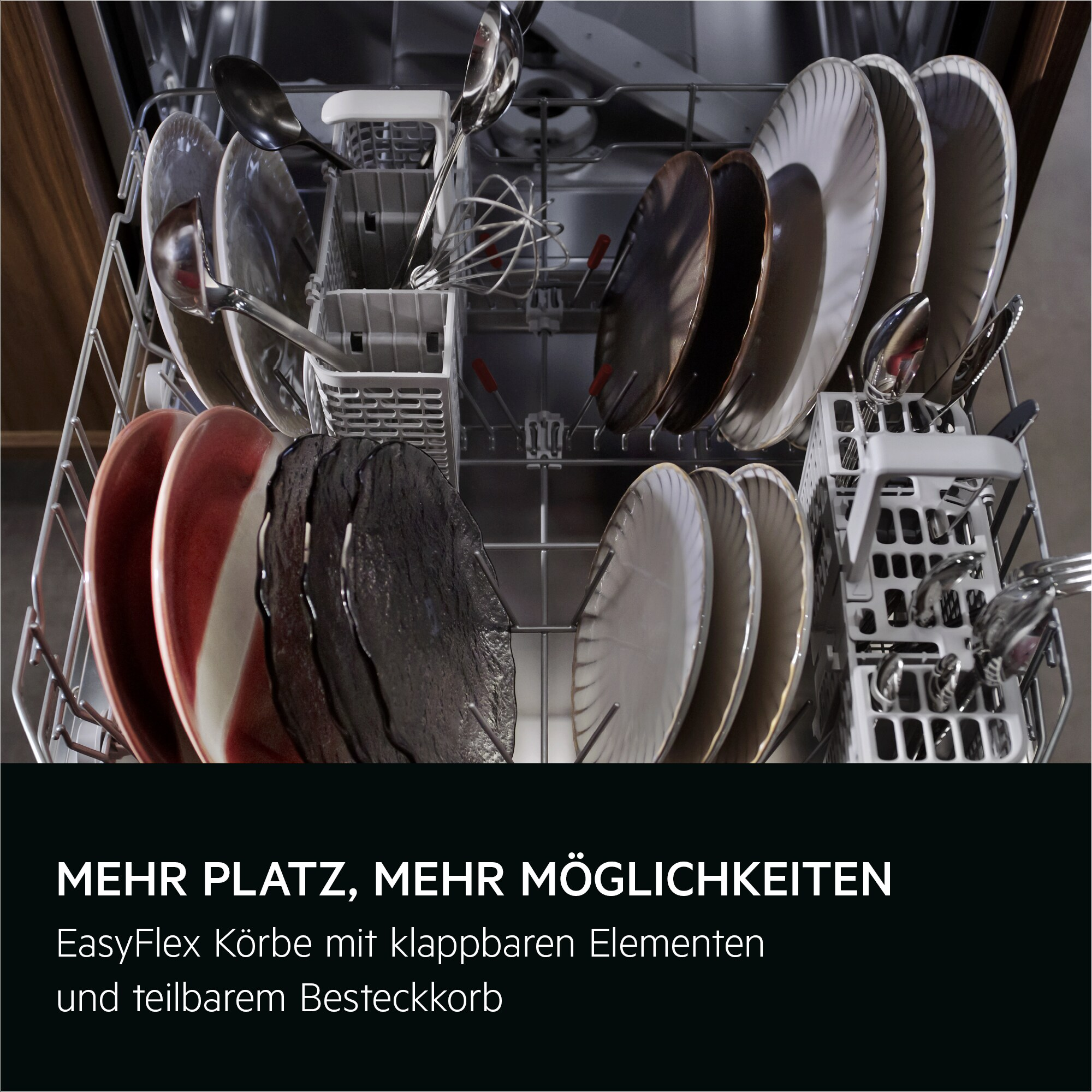 Innenraum des Geschirrspülers mit Tellern, Utensilien und Besteck. Rote, schwarze und weiße Teller sind sichtbar. Utensilien sind in Körben.