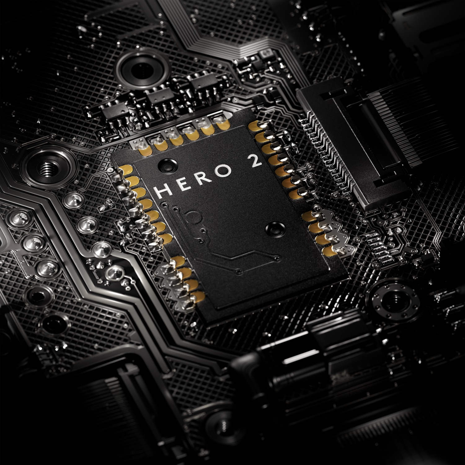 Primo piano di un circuito stampato nero con la scritta 'HERO 2'. Componenti dorati visibili. Lo sfondo è scuro.
