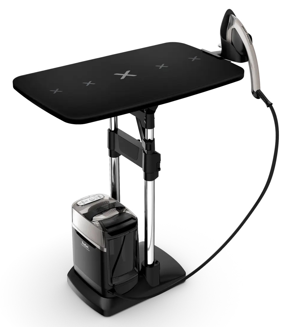 Czarna deska do prasowania z żelazkiem. Deska ma znaki X. Czarna podstawa trzyma zbiornik na wodę. Żelazko jest srebrne i czarne.