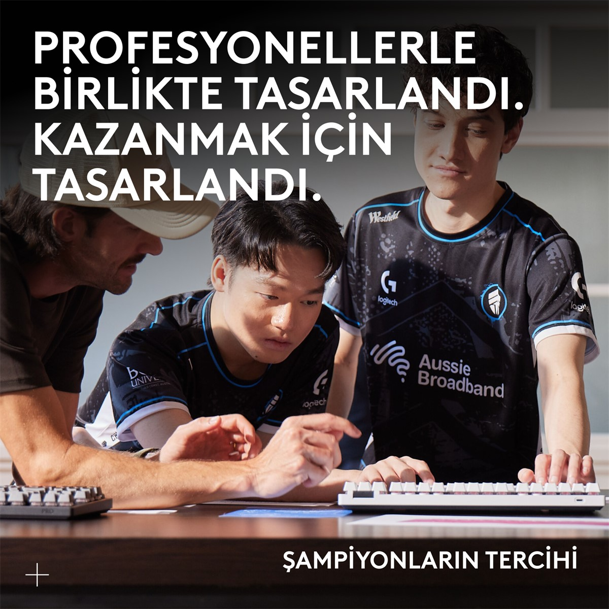 Üç adam bir klavyeye bakıyor. Resmin üstünde ve altında Türkçe metin.