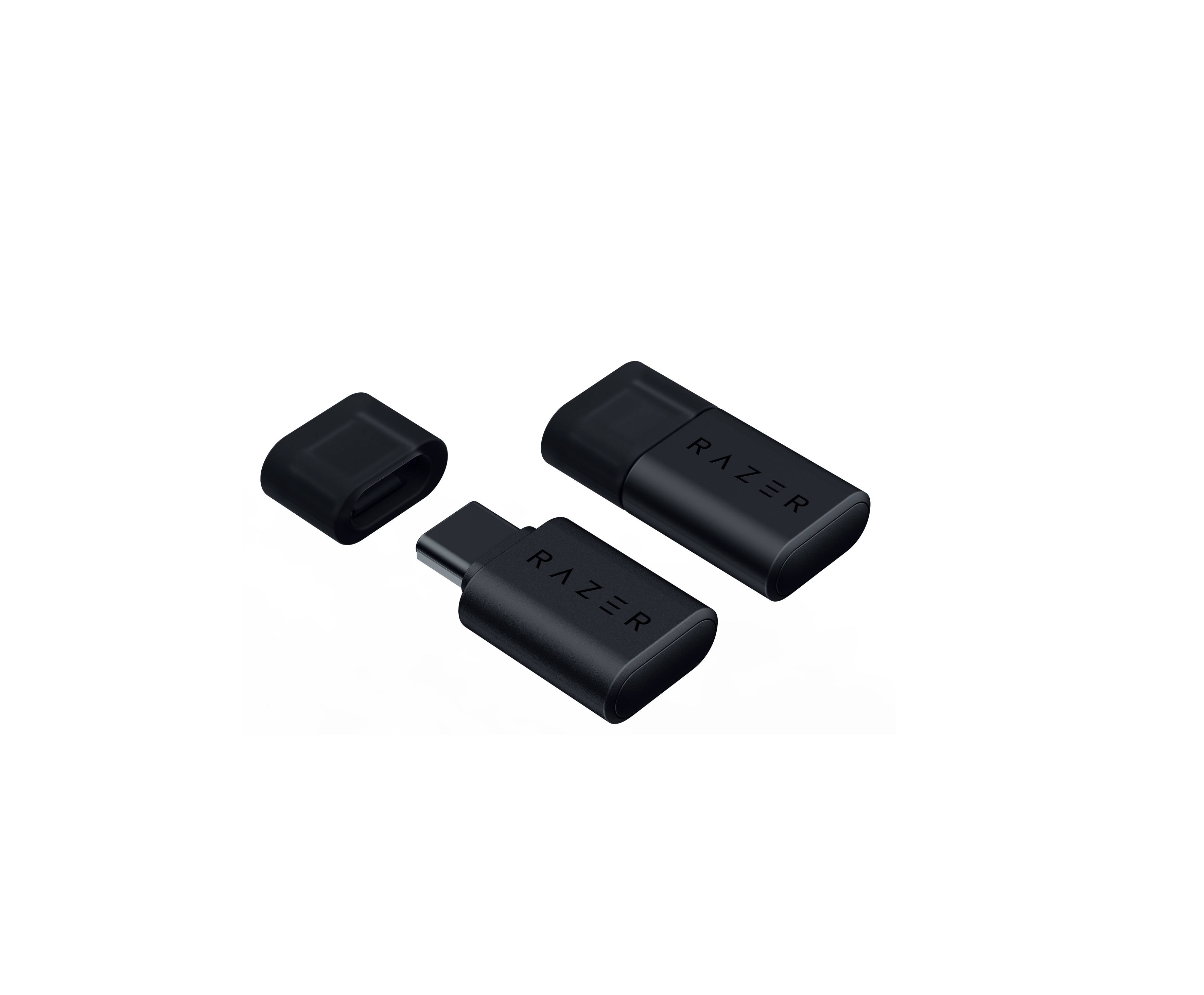 Siyah Razer USB adaptörü, kapağı çıkarılmış. Ayrıca biri kapaklı olmak üzere iki adaptör daha görünür.