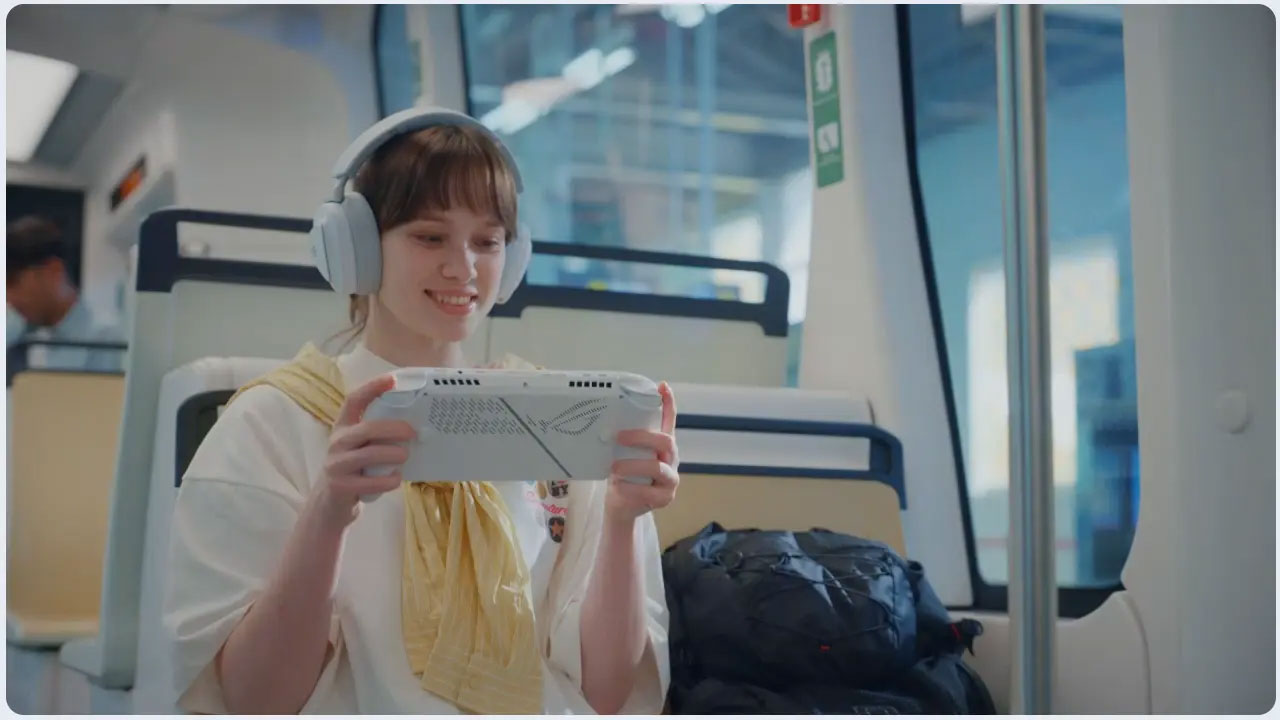 Kobieta w słuchawkach gra w grę przenośną w pociągu. Uśmiecha się, trzymając urządzenie. Plecak leży w pobliżu.