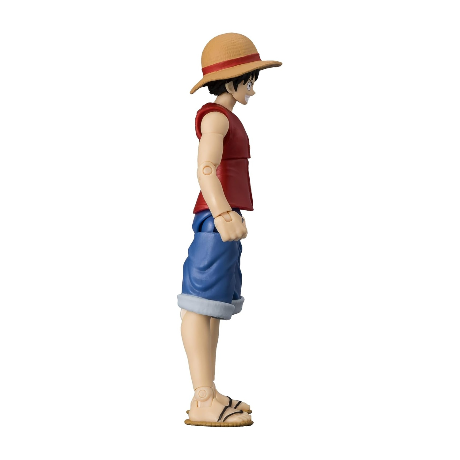 Una vista laterale di una figura di Luffy. Ha un cappello di paglia, un gilet rosso, pantaloncini blu e sandali. Lo sfondo è bianco.
