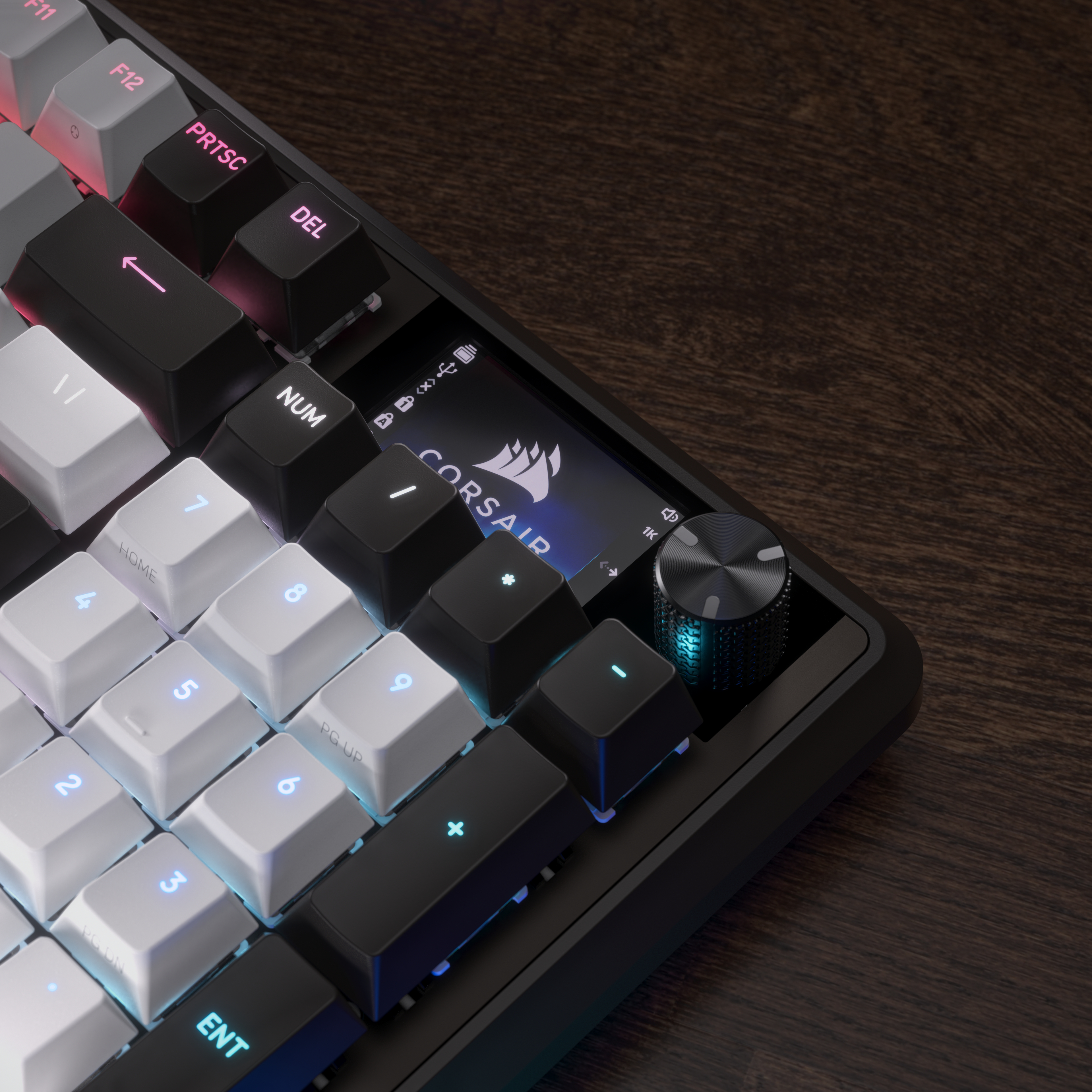 Nahaufnahme einer schwarz-weißen Tastatur mit Corsair-Logo und Lautstärkeregler auf Holzoberfläche.