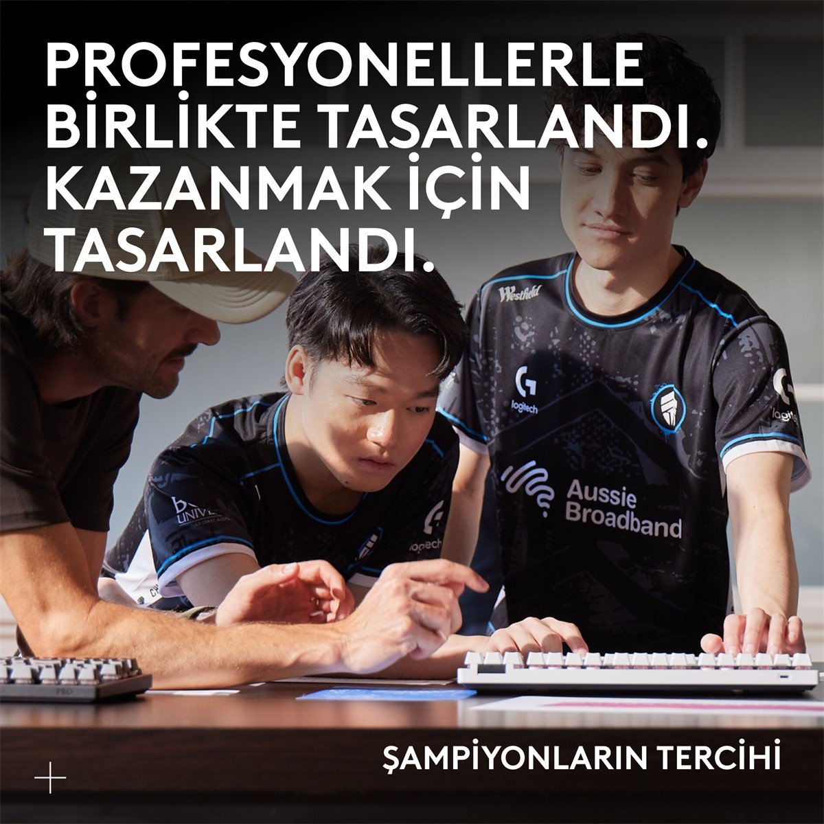 Üç adam bir klavyeye bakıyor. Türkçe metin: profesyonellerle tasarlandı, kazanmak için tasarlandı, şampiyonların tercihi.