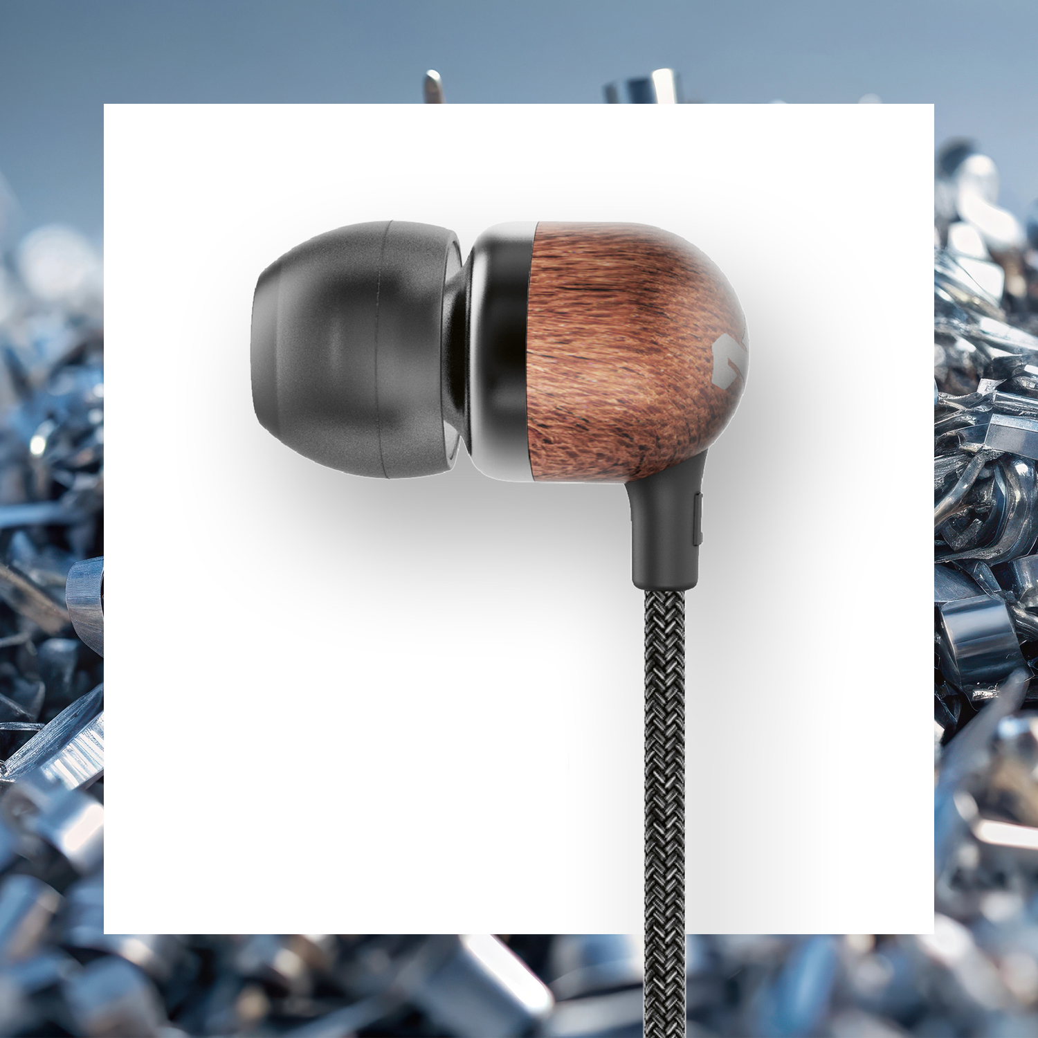 Oordopje met houten afwerking, zwarte accenten en gevlochten kabel. Op een witte achtergrond, omringd door metaalschaafsel.