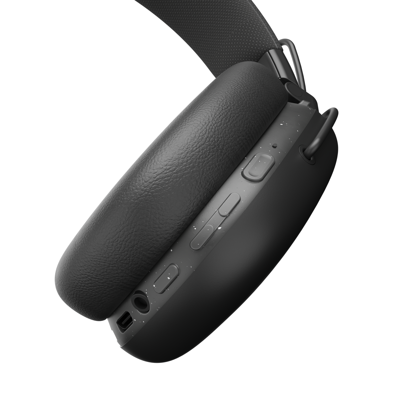 Close-up of black headphones. The ear cup and headband are visible against a black background. Controls are on the ear cup.