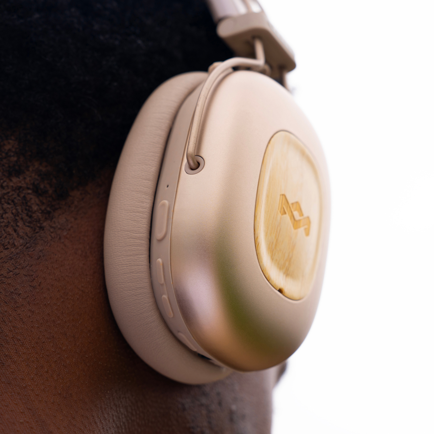 Gros plan d'une personne portant un casque beige. Une partie de la tête et du cou de la personne sont visibles. Fond blanc.
