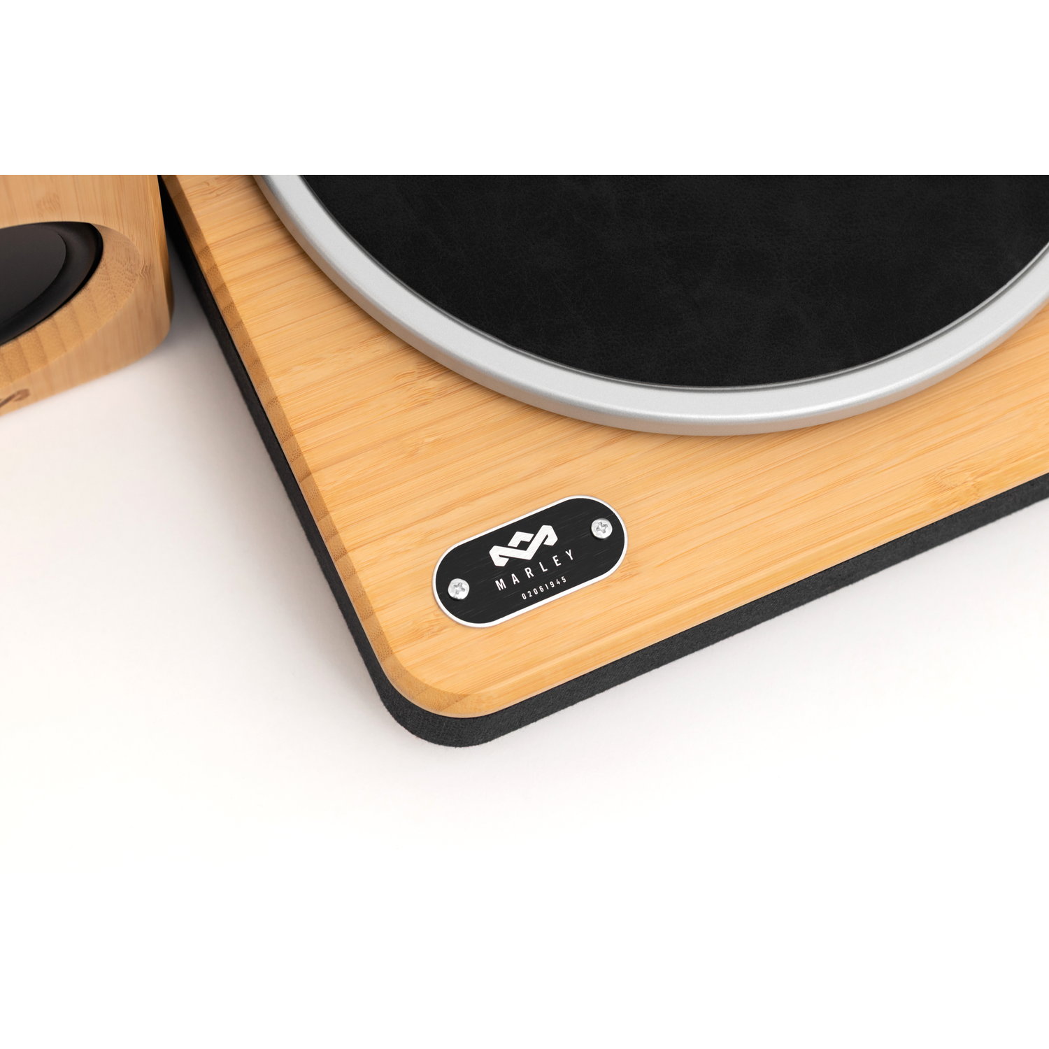 A wooden turntable with a black record, silver arm, and speaker. A black and white logo is on the turntable.