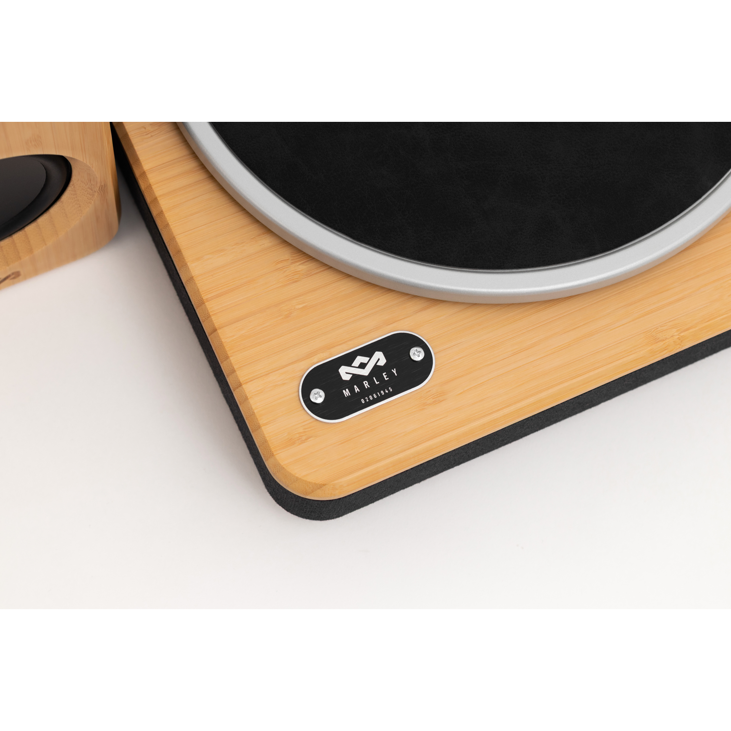 A close-up of a wooden record player with a black platter. The brand name and logo are visible. The background is white.