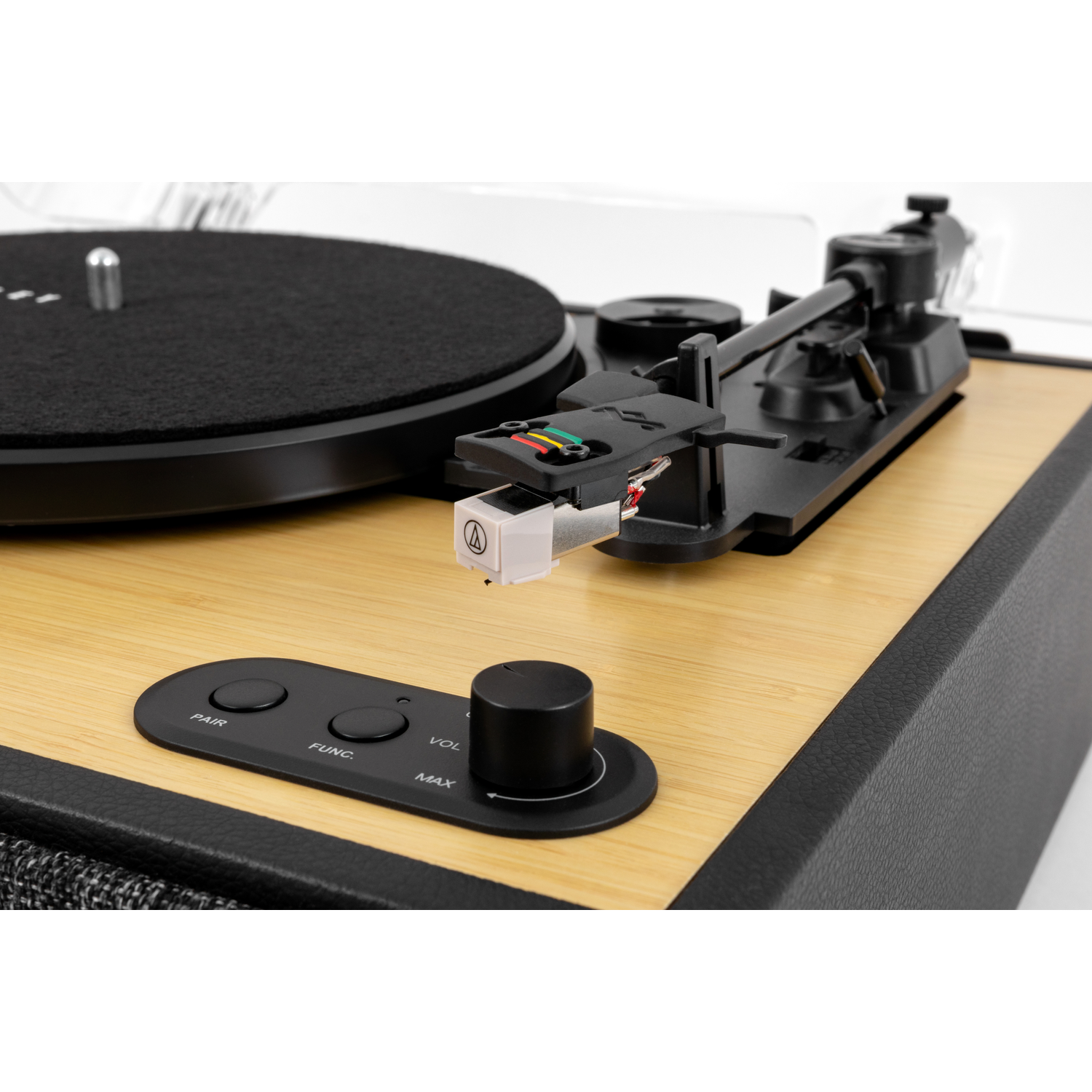 A close-up of a record player. It has a black turntable, wooden base, and a black arm with a white cartridge.