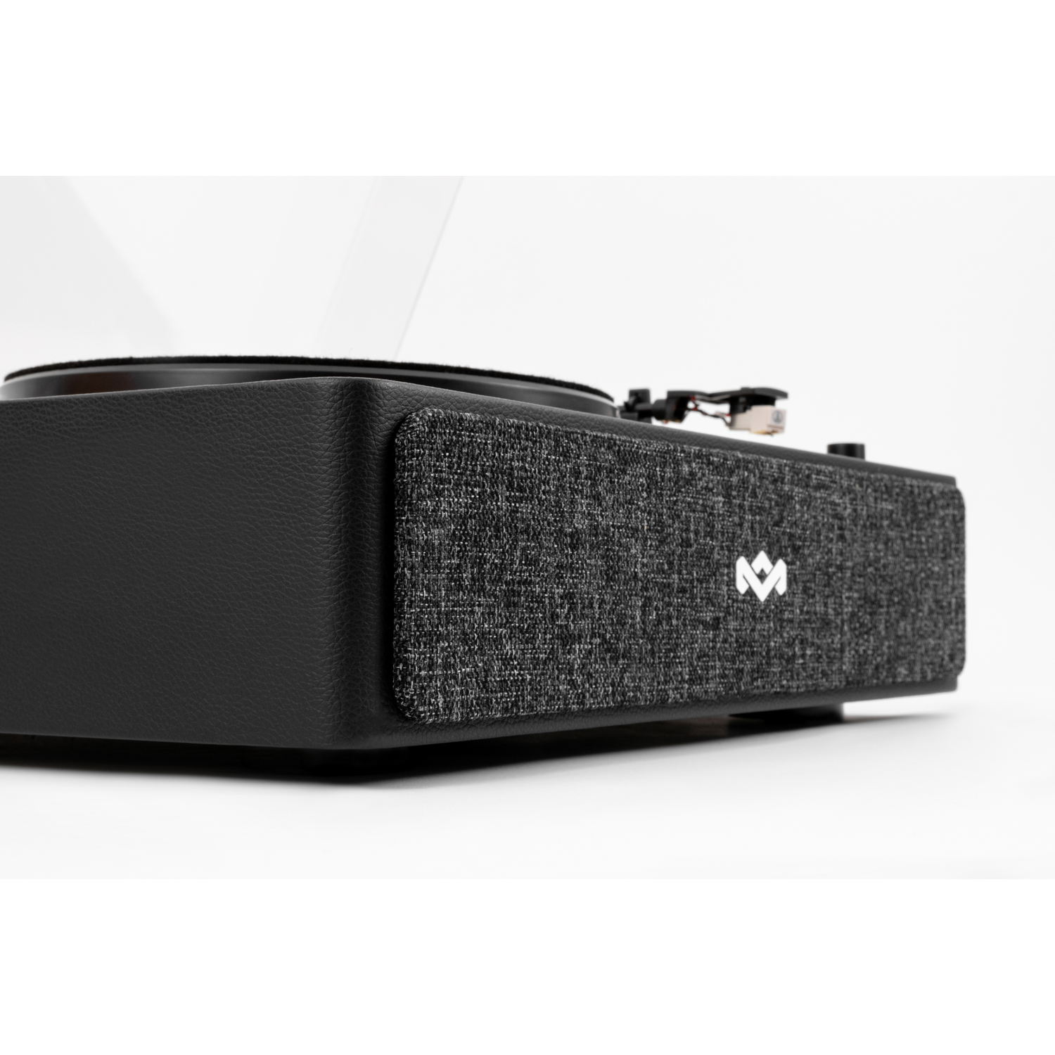 A black turntable with a gray speaker. The turntable has a needle and a record. The speaker has a logo.