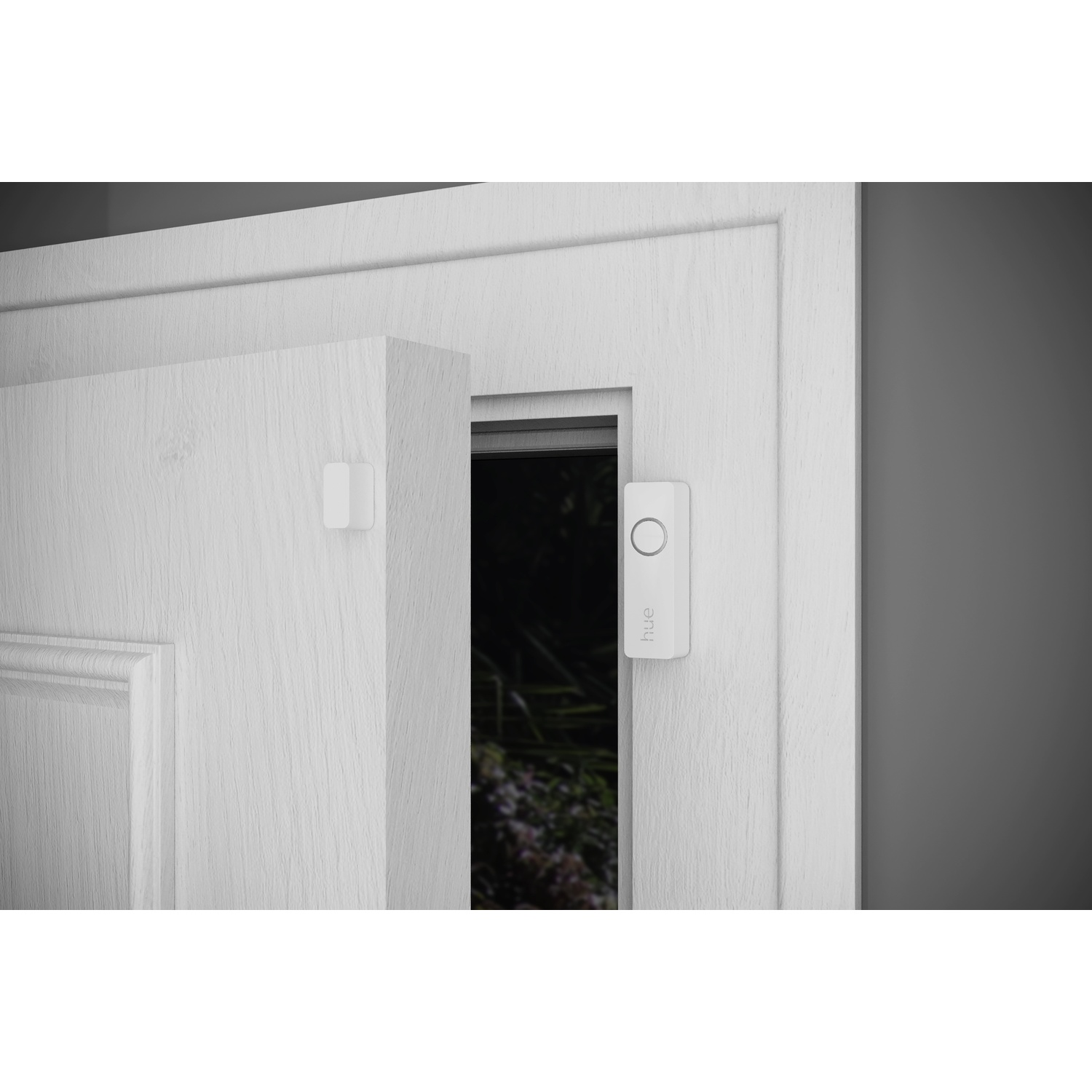 Una porta bianca con una sezione parzialmente aperta che rivela una vista esterna scura. Un campanello bianco è montato sul telaio della porta.