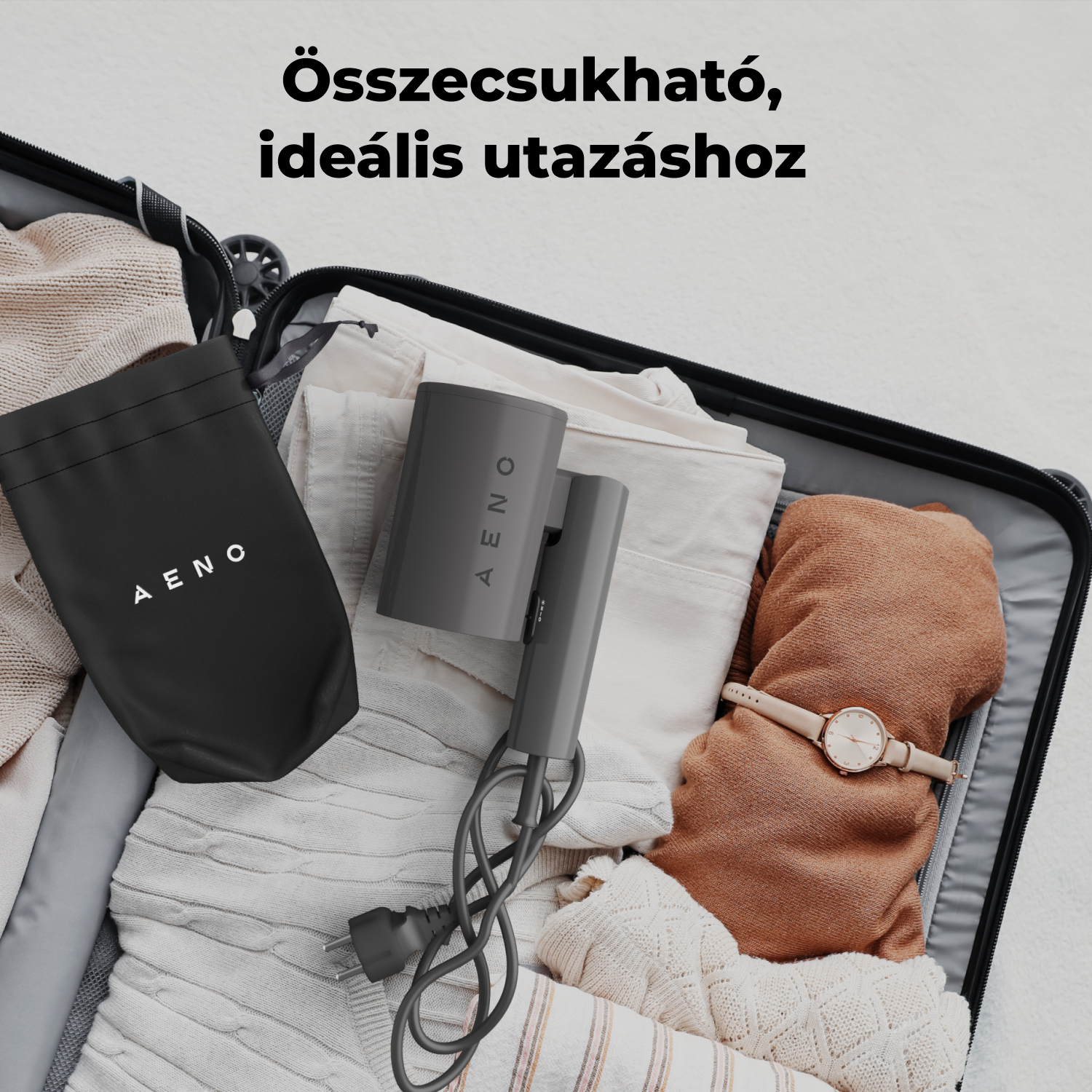 Nyitott bőrönd, tele ruhákkal, órával és hajszárítóval, rajta 'AENO' felirattal. Egy fekete táska, rajta 'AENO' felirattal, a tetején.