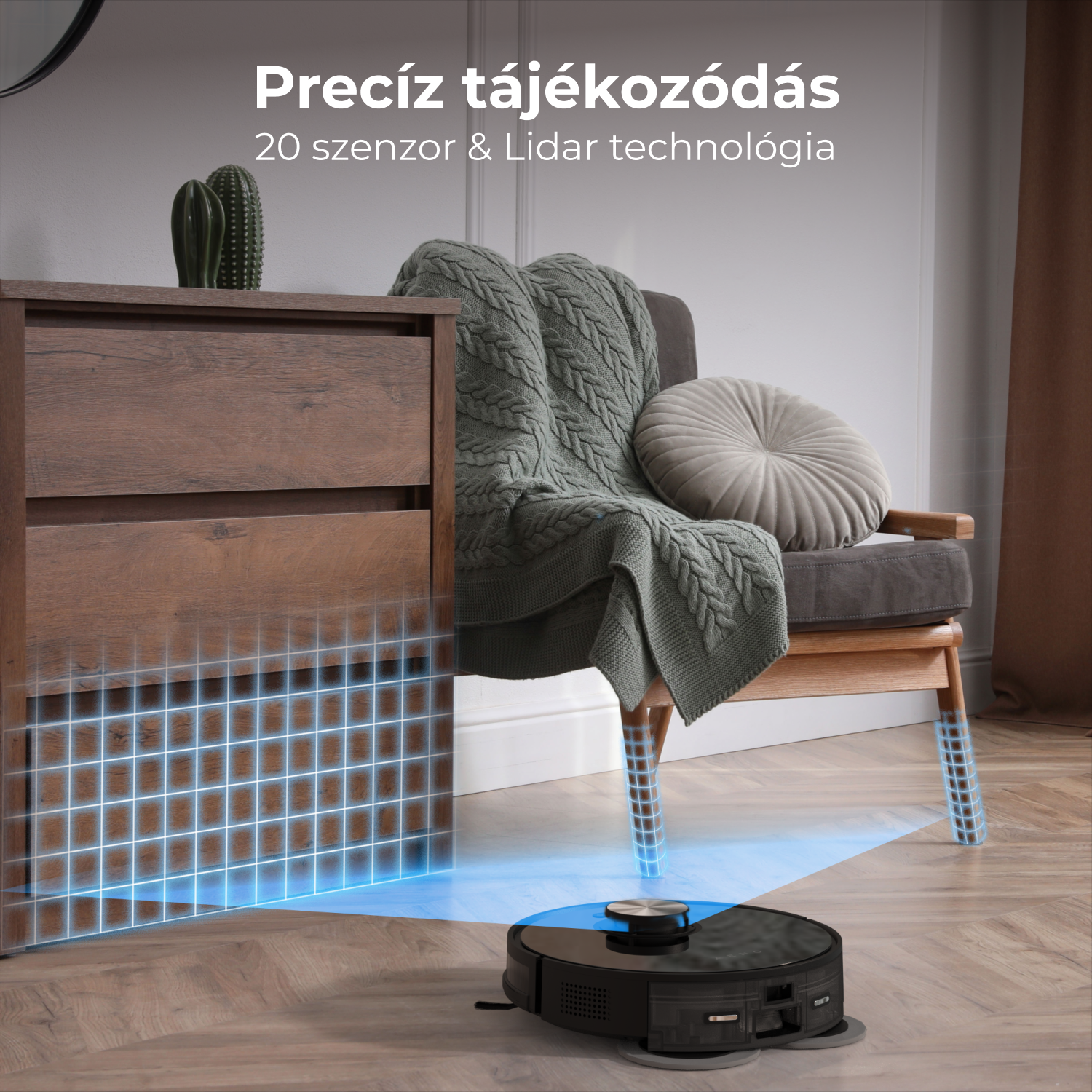 Egy fekete robotporszívó a fa padlón. Egy fa szekrény, egy takaróval ellátott szék és egy kaktusz is látható.
