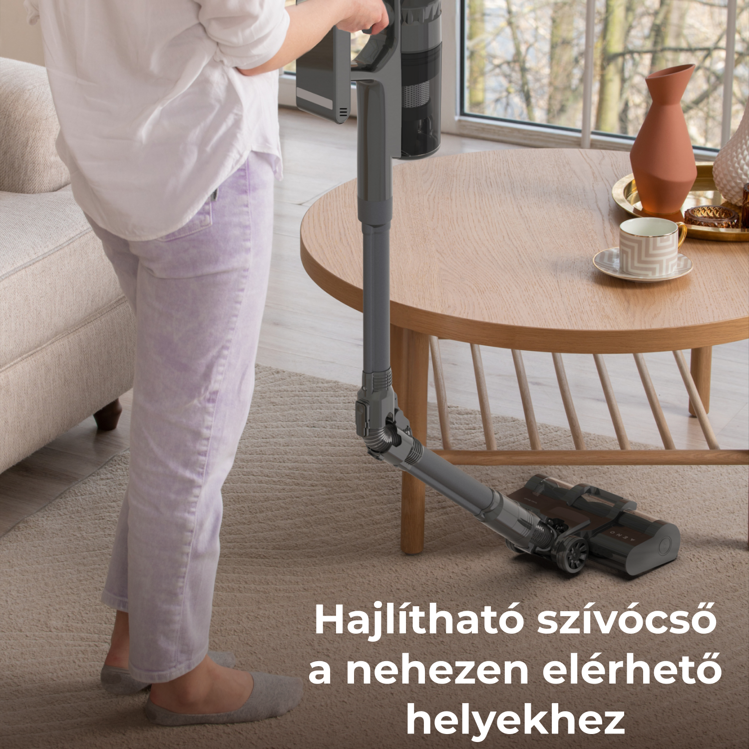 Egy személy egy hajlított porszívóval porszívózza a szobát. A háttérben egy váza és csésze található az asztalon. A padló szőnyeggel borított.