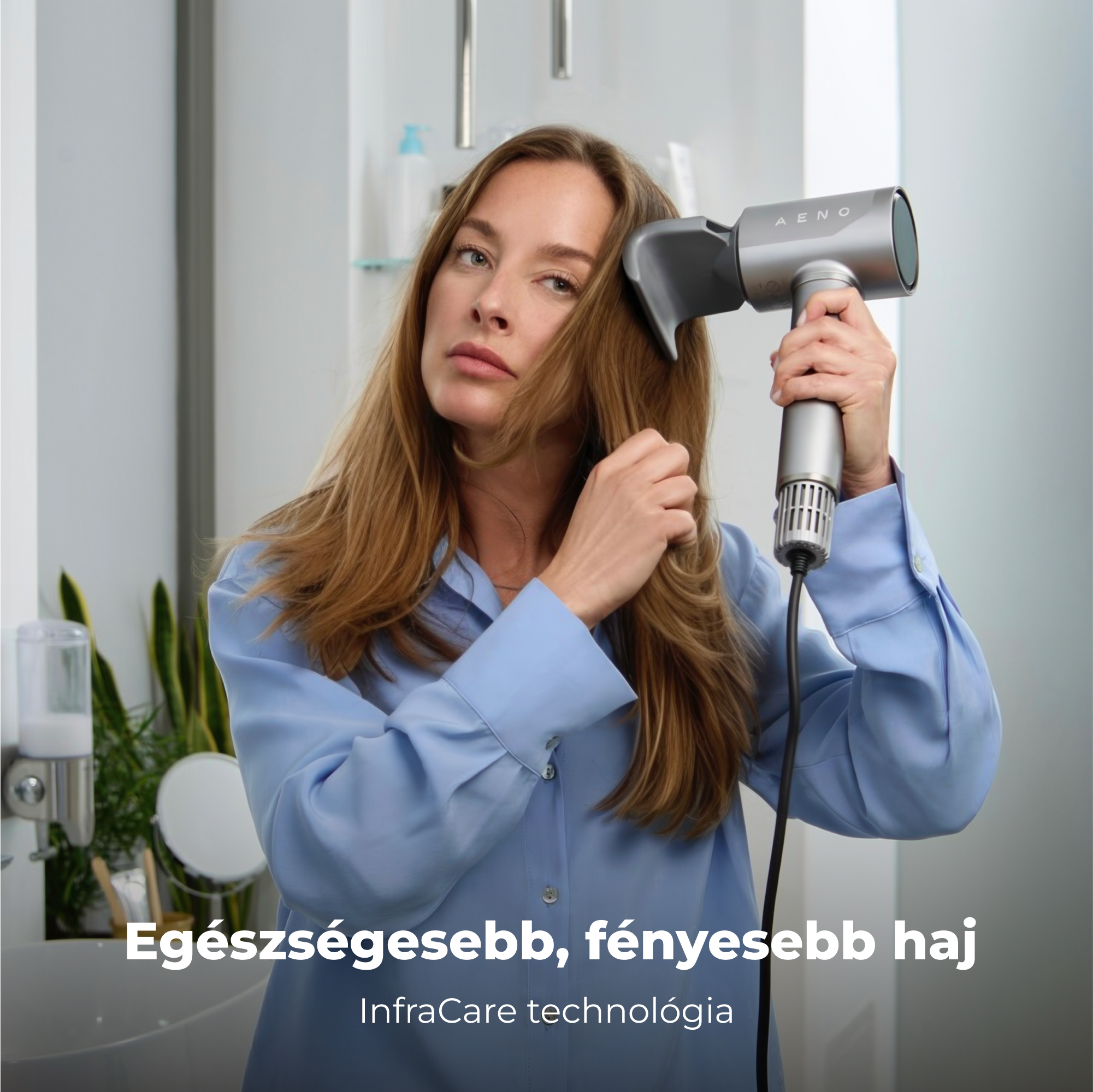Egy nő szárítja a haját egy ezüst hajszárítóval. Egy fürdőszobában van. Alatta a szöveg: 'Egészségesebb, fényesebb haj'.