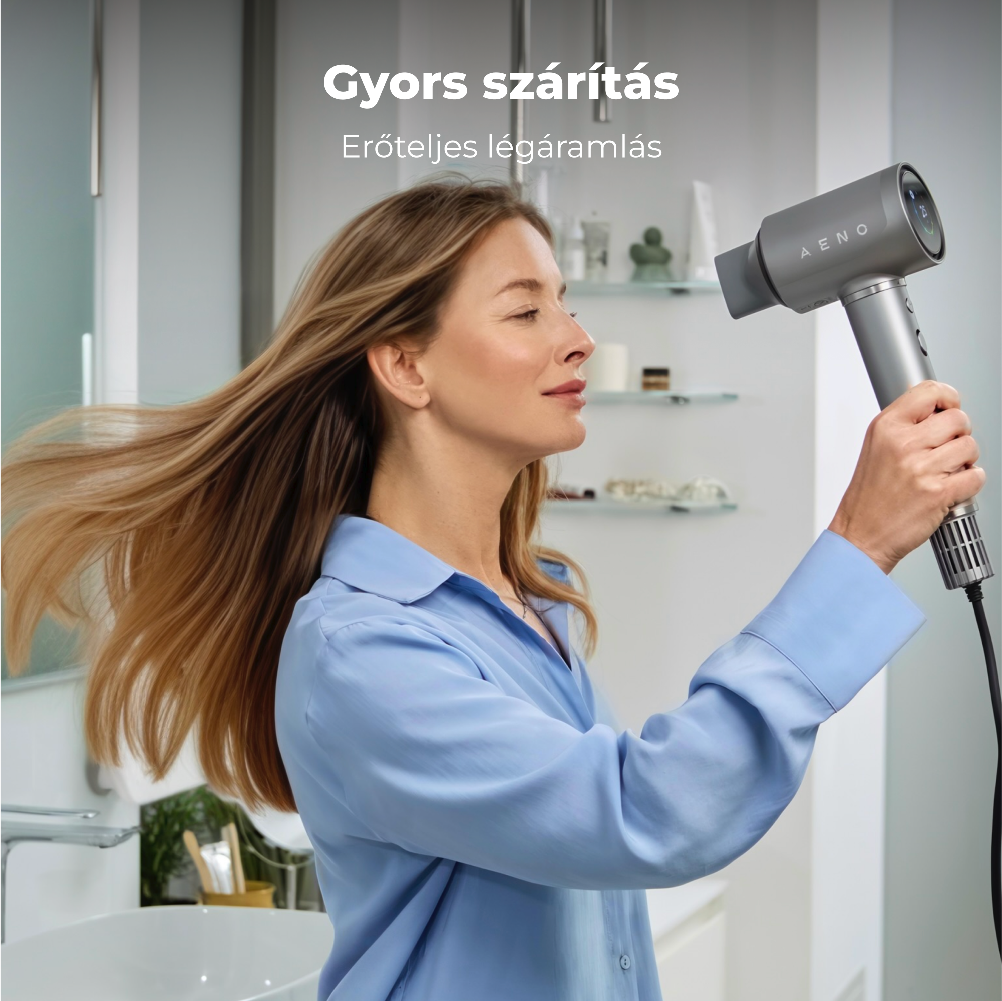 Nő hajszárítóval szárítja a haját a fürdőszobában. Kék inget visel. A haja lobog. Magyar nyelvű felirat.