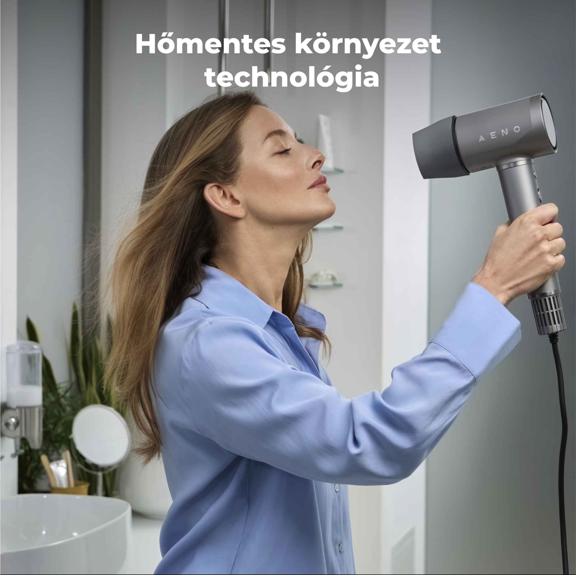 Kék inges nő szürke hajszárítót használ. Magyar szöveg: Hőmentes környezet technológia. Háttérben fürdőszoba.