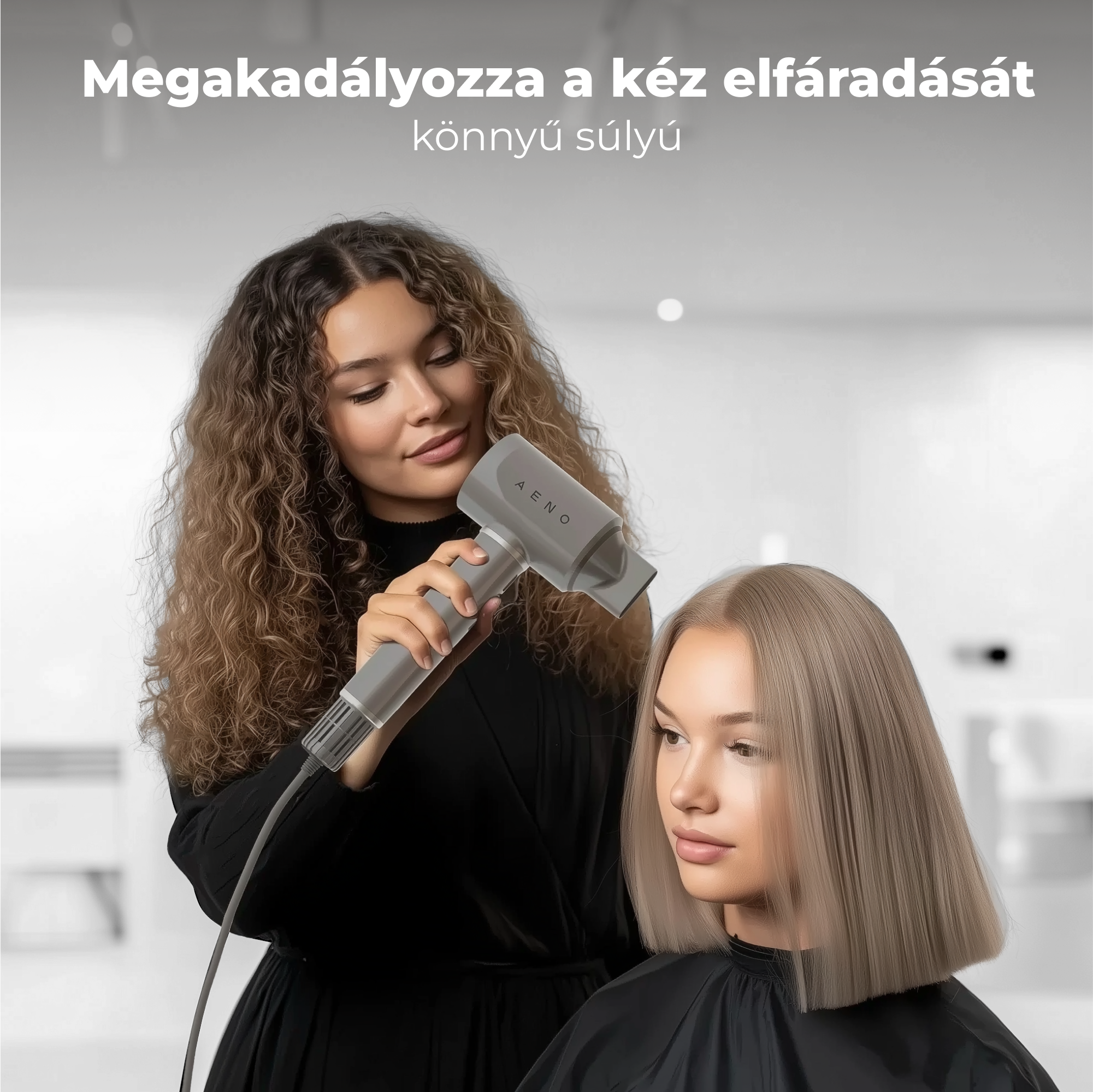 Egy stylist egy szürke hajszárítóval szárítja egy vendég szőke haját. A vendég egyenes hajú. A háttér elmosódott.