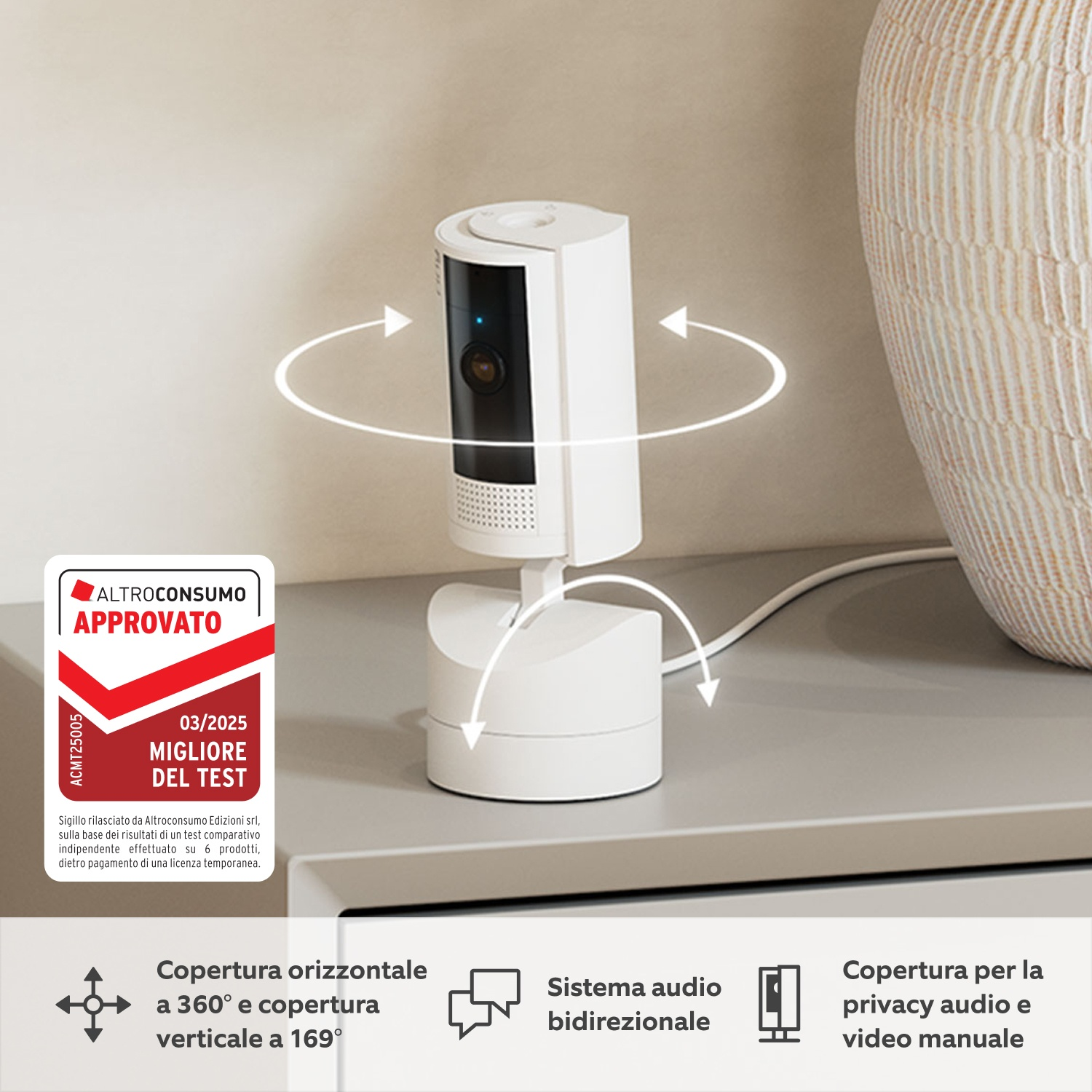 Una telecamera di sicurezza bianca è su una superficie grigia. C'è un vaso sullo sfondo. Un'etichetta dice 'Approvato' e 'Miglior test'.