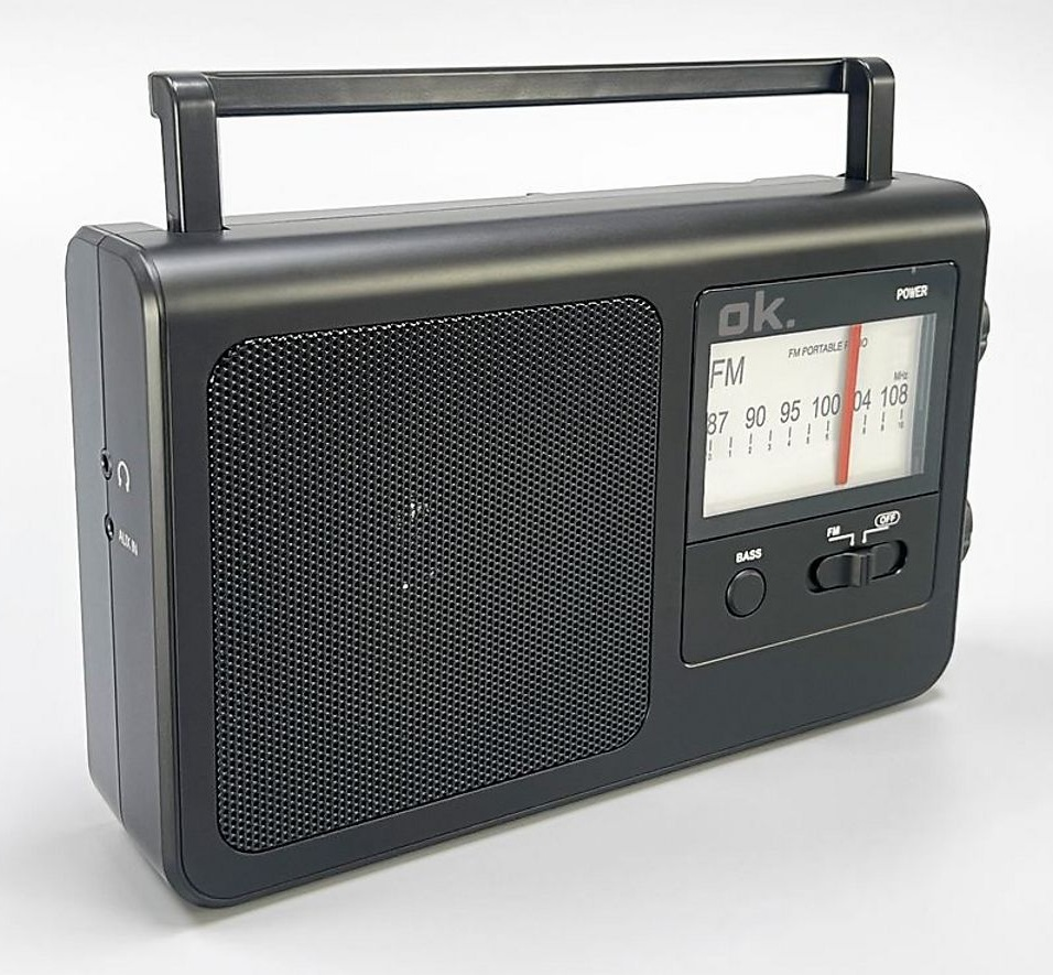 Czarno-czarne przenośne radio z uchwytem, głośnikiem, pokrętłem strojenia i przyciskami. Radio stoi na białej powierzchni.