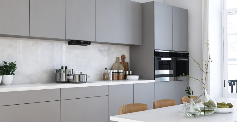 Nowoczesna kuchnia z szarymi szafkami, urządzeniami ze stali nierdzewnej i białymi blatami. Zawiera garnki, deski do krojenia i stół jadalny.