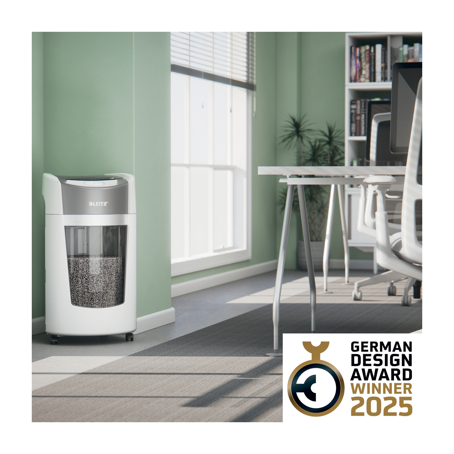 Un ufficio con un tritadocumenti, una scrivania e una finestra. Il tritadocumenti è bianco e grigio. La stanza ha una parete verde e un tappeto grigio.