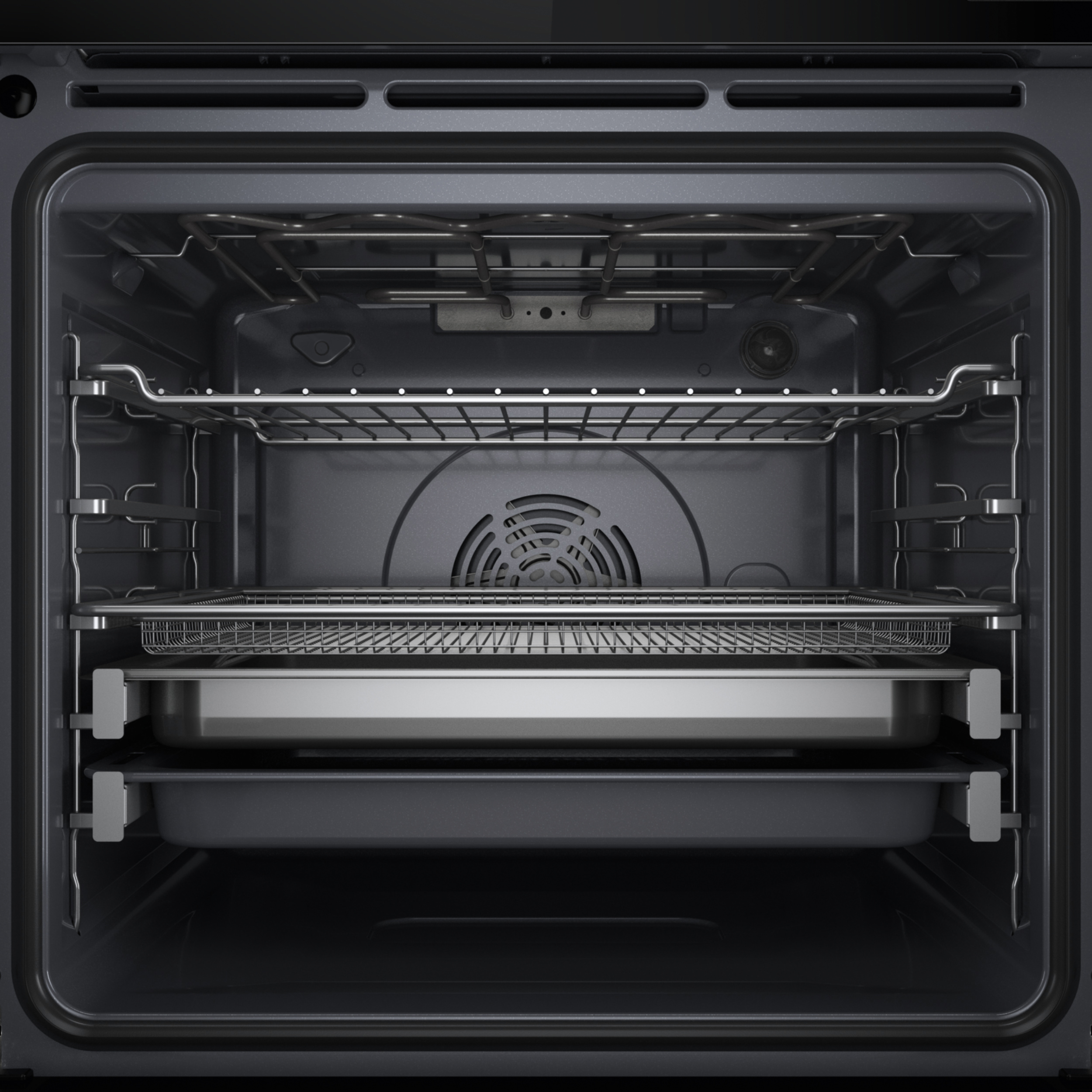 Wnętrze ciemnego piekarnika, z rusztami, tacą i wentylatorem.