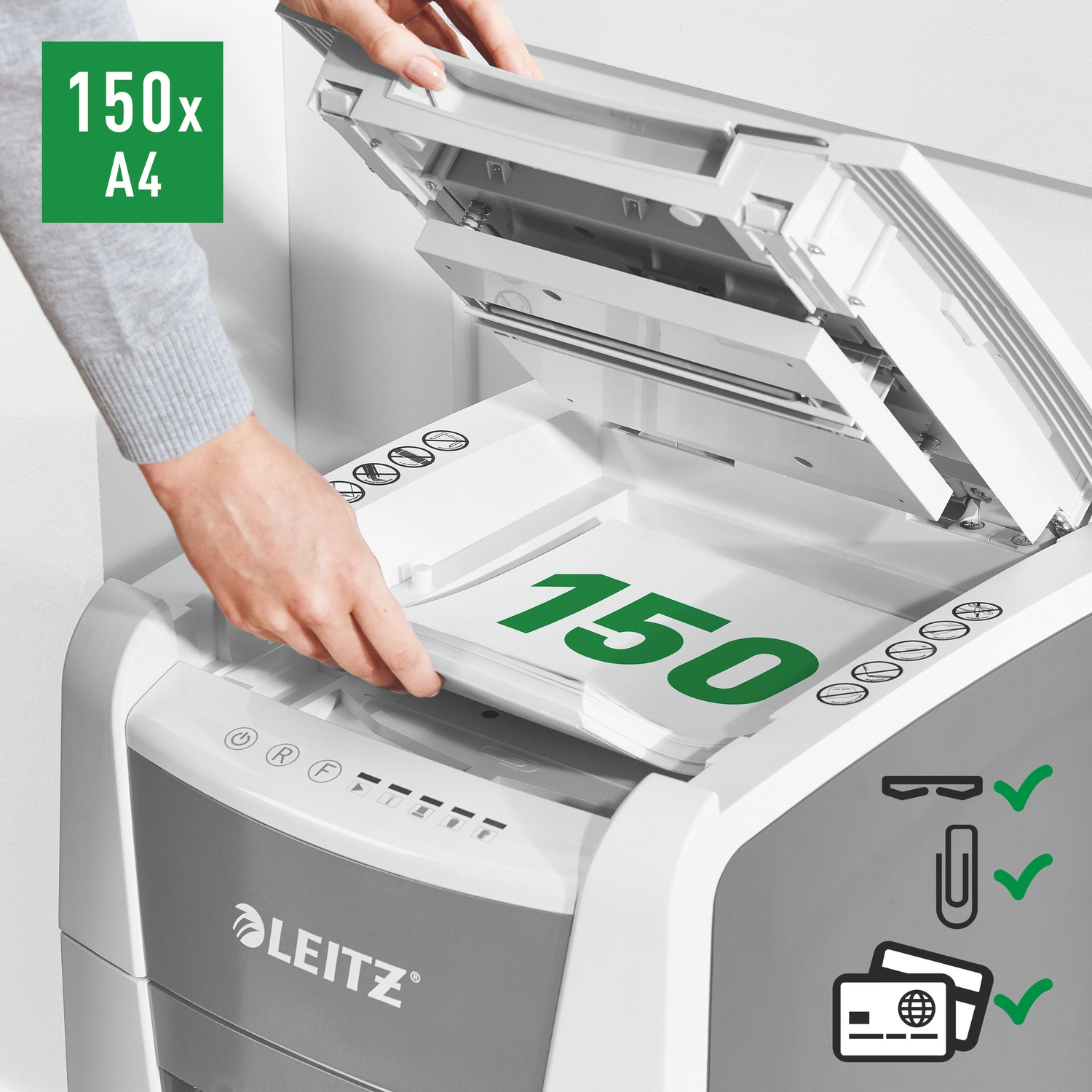 Una persona sta inserendo della carta in un distruggi documenti Leitz. Il distruggi documenti è bianco e grigio. La carta mostra il numero 150 in verde.
