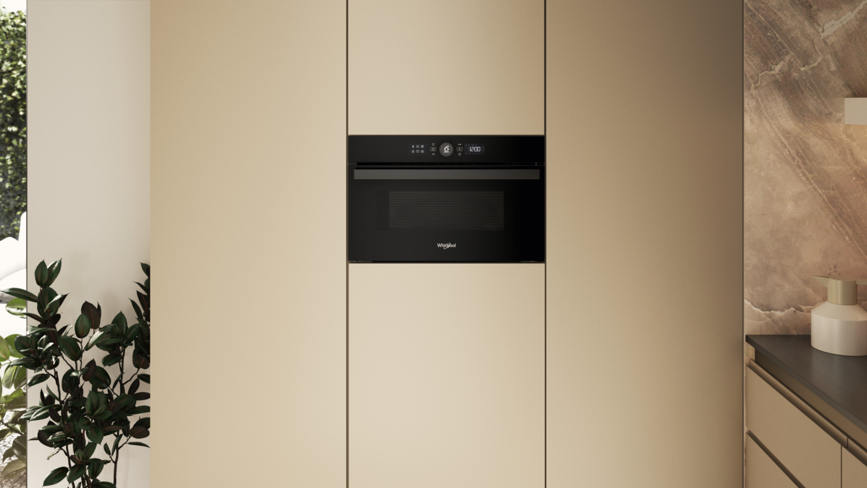 Czarna kuchenka mikrofalowa jest umieszczona na środku beżowej szafki. Po lewej roślina, po prawej marmurowa ściana.