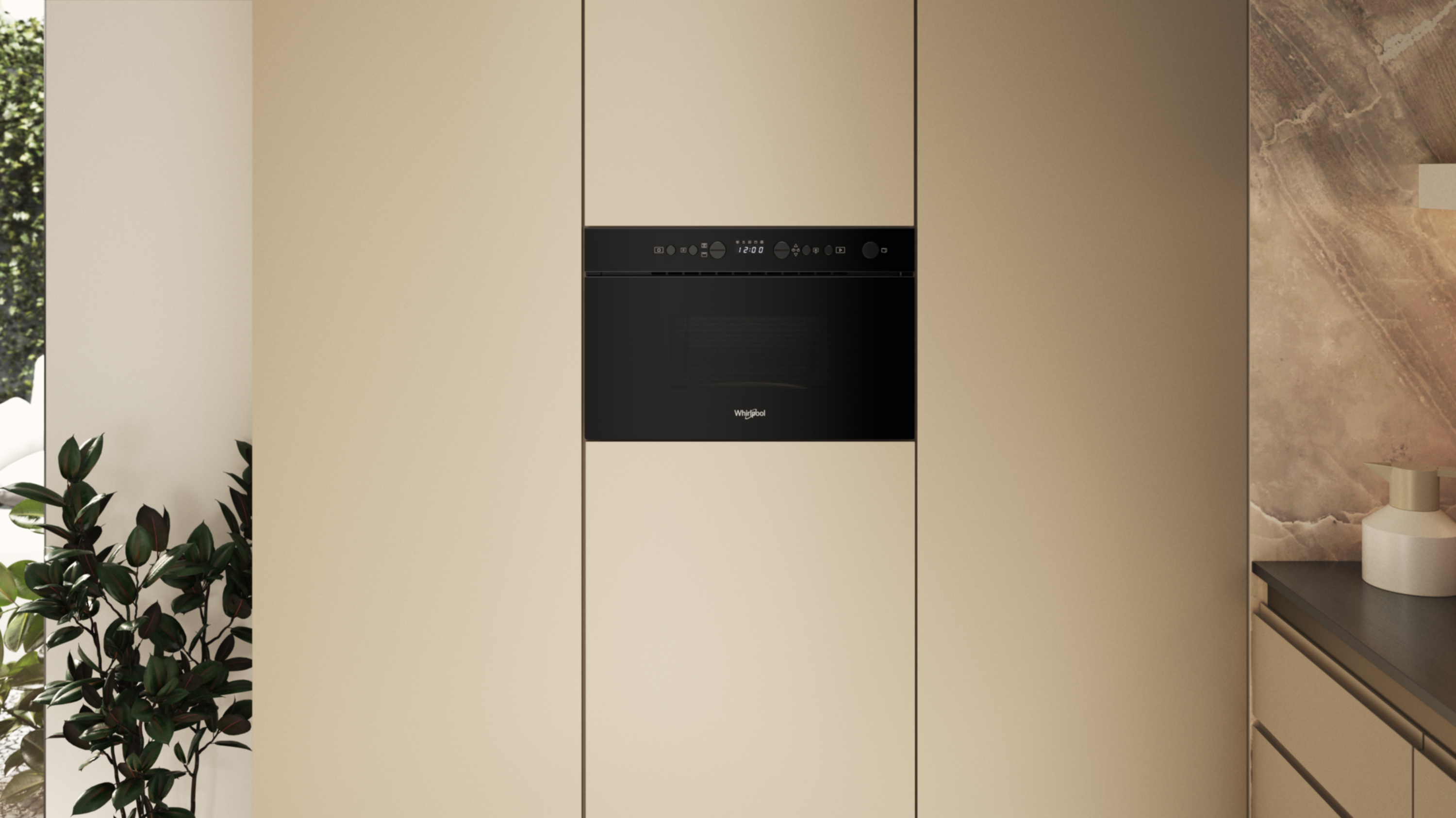 Czarna kuchenka mikrofalowa Whirlpool jest wyśrodkowana na jasnobeżowej szafce. Po lewej stronie widoczne są liście, a po prawej blat.
