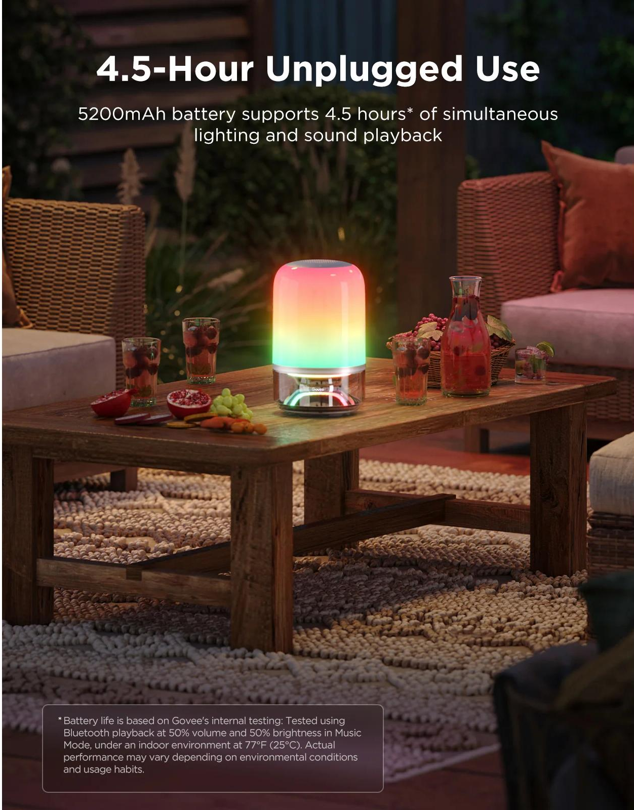 Un tavolo con bevande, frutta e una lampada che cambia colore. Un'accogliente ambientazione esterna con tavolo e sedute in legno.