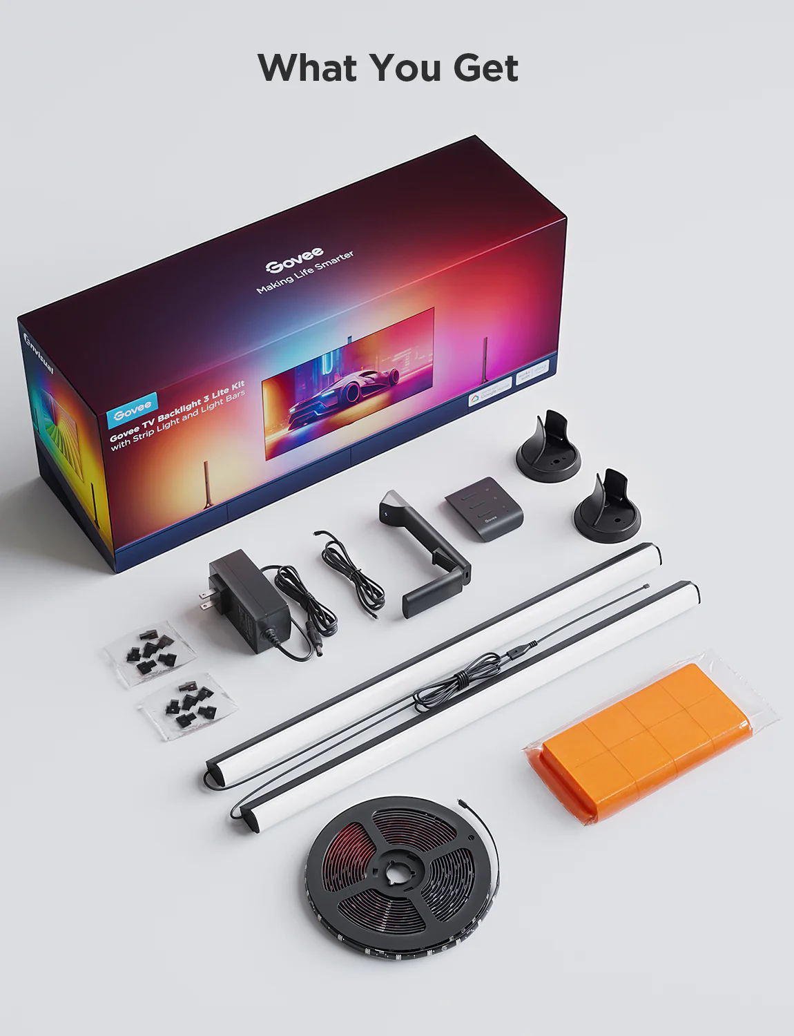 Kit retroilluminazione TV Govee con luci, strisce, adattatore di alimentazione e accessori su una superficie bianca. La scatola è visibile.