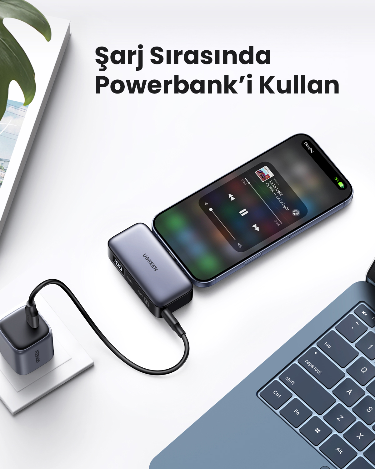 Bir telefon, powerbank ve adaptör ile şarj oluyor. Bir dizüstü bilgisayar klavyesi görünür. Metin şöyle diyor: 'Şarj Sırasında Powerbank Kullan'.