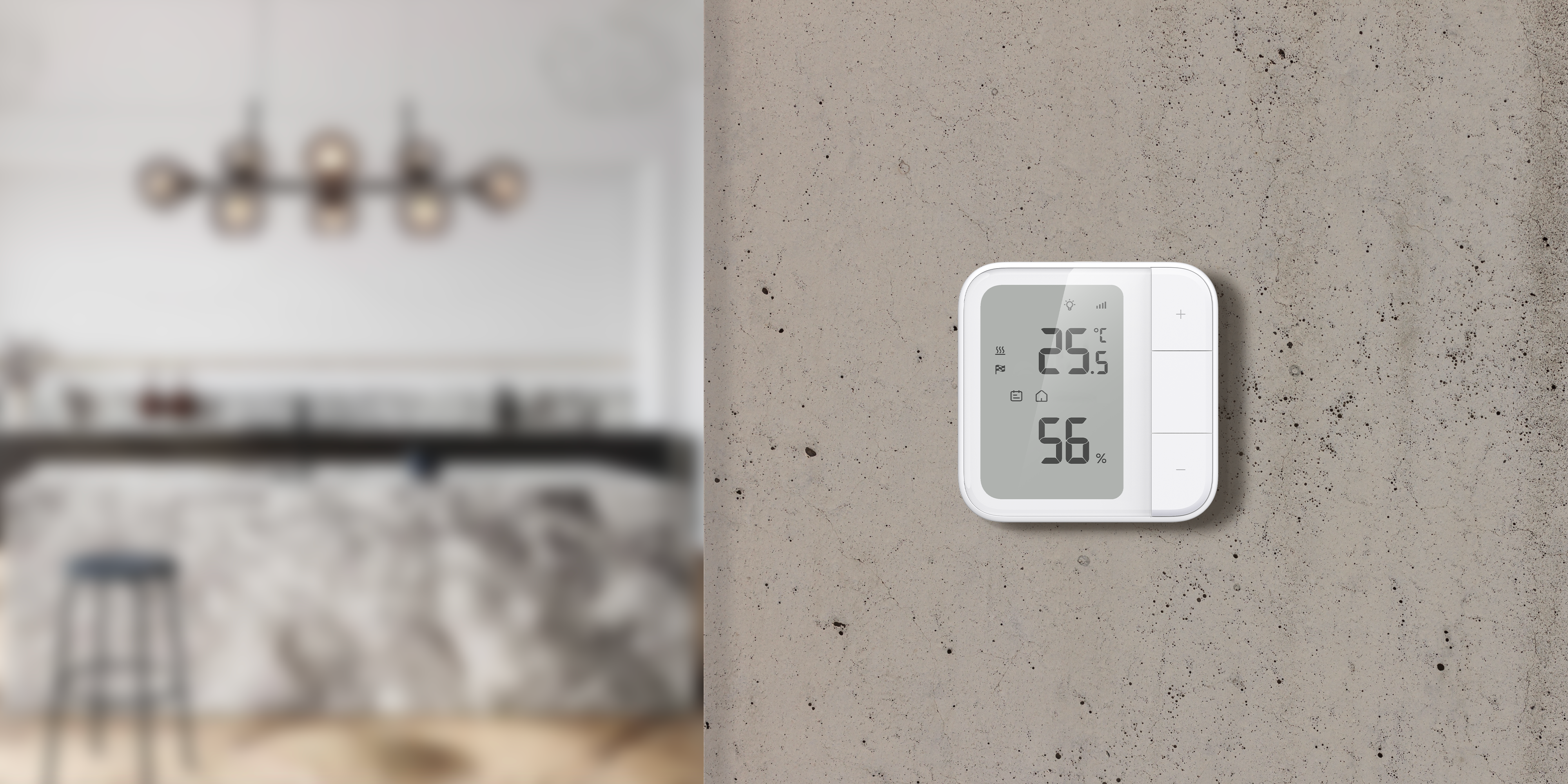 Ein weißes Thermostat an einer Betonwand zeigt Temperatur und Luftfeuchtigkeit an. Der Hintergrund zeigt eine verschwommene Küchenszene.